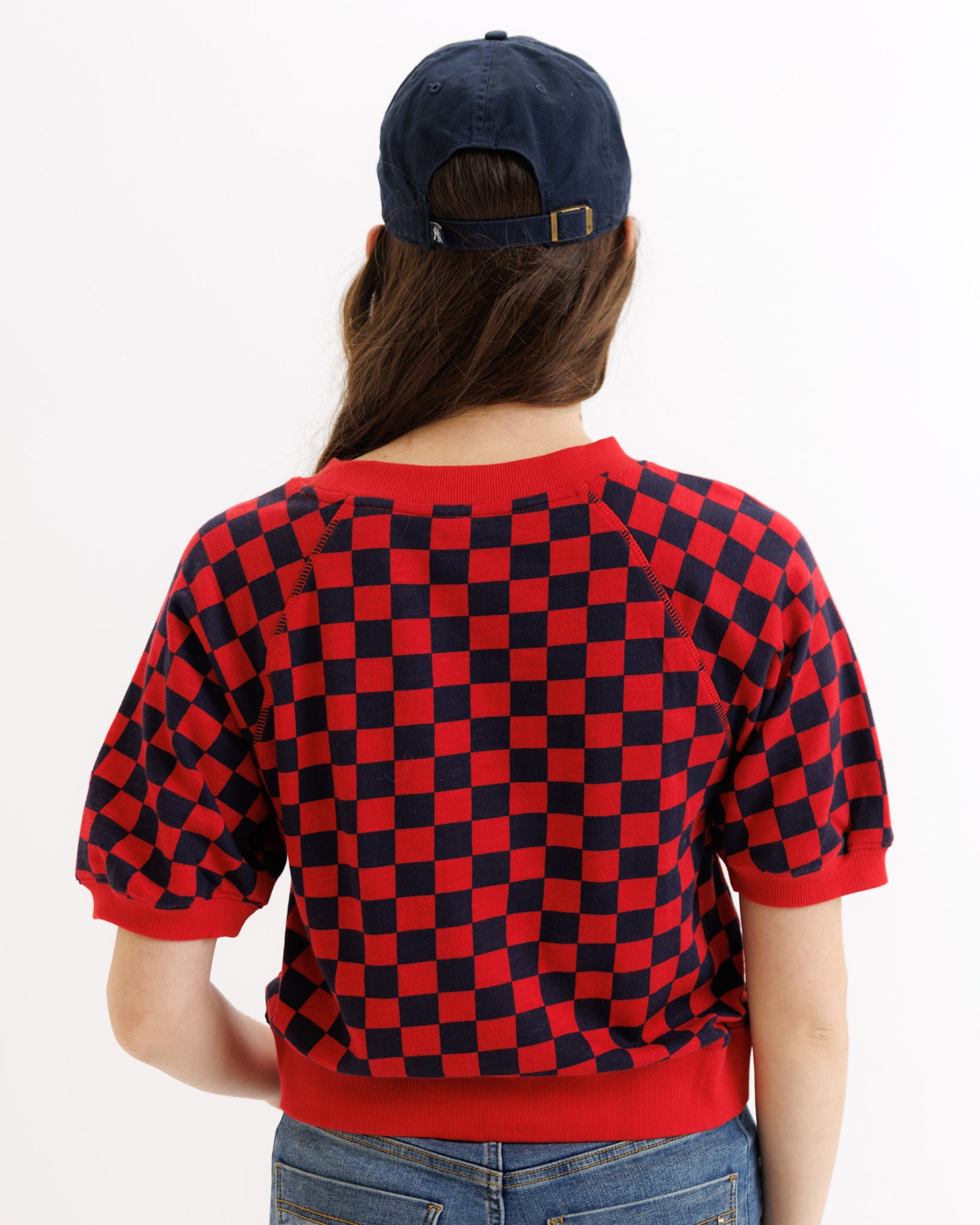 Person wearing a red and black checkered shirt with a white background