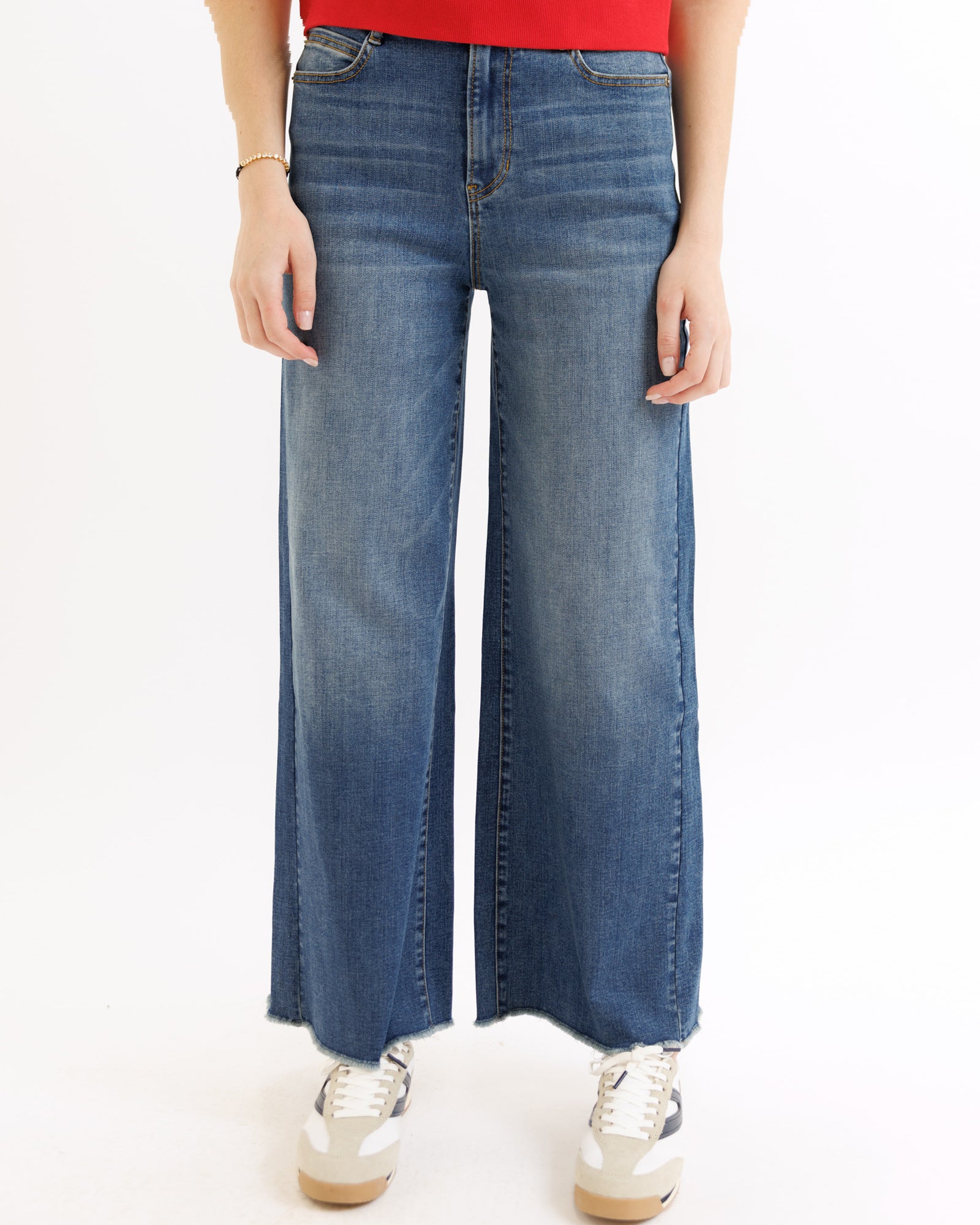 Person wearing blue wide-leg jeans on a white background