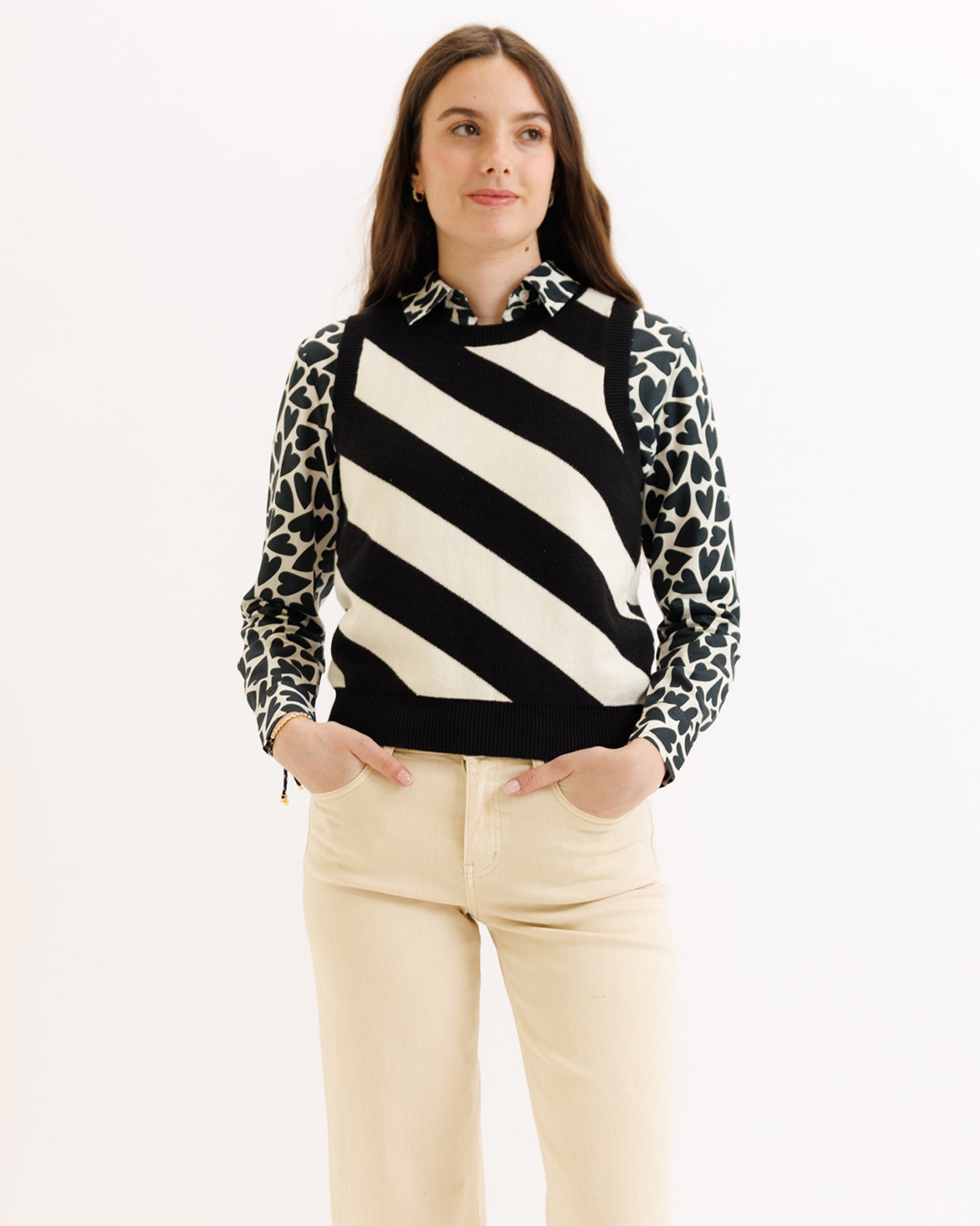 Woman wearing a black and white striped sweater with leopard print sleeves on a white background
