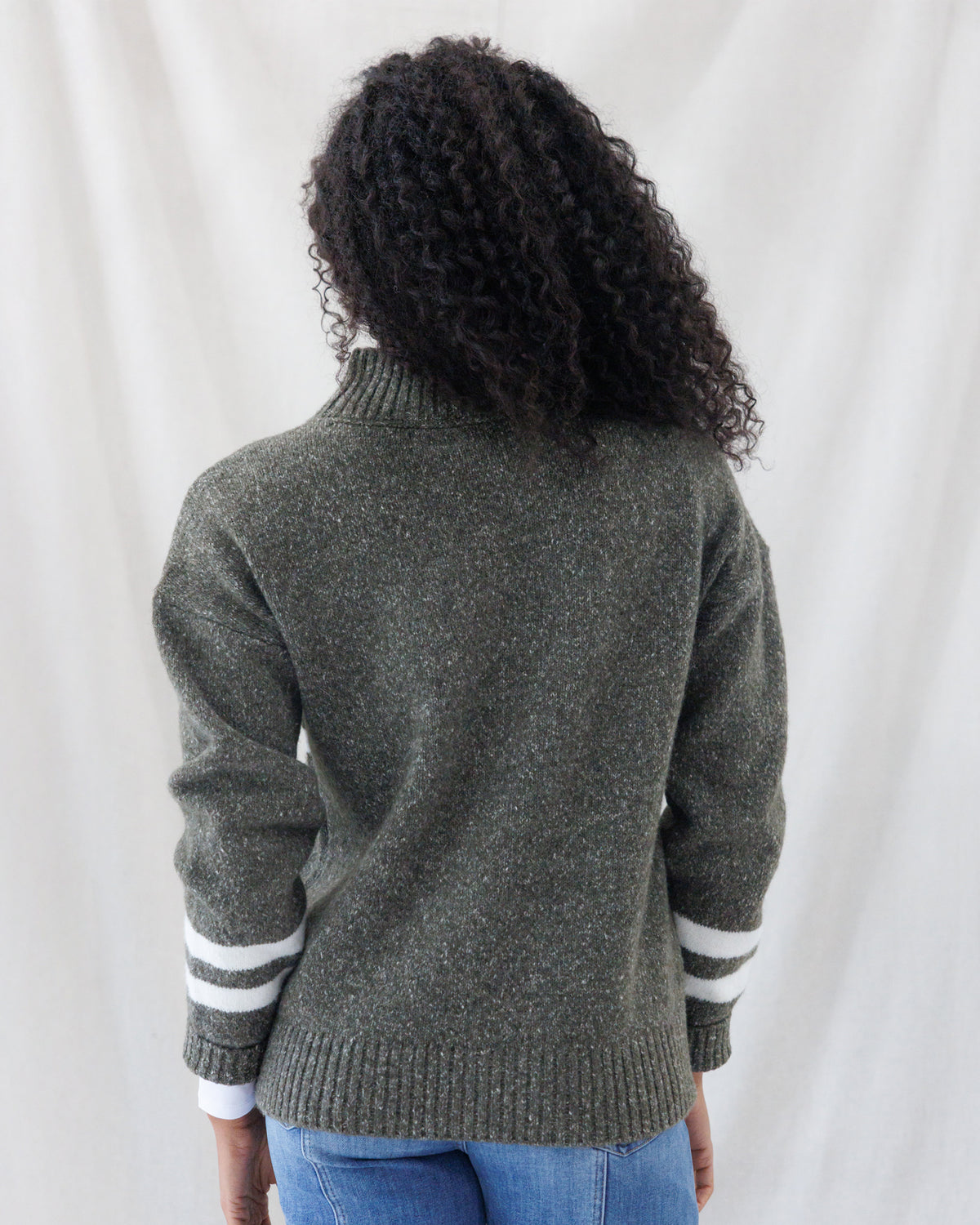 Back view displaying the heathered olive knit texture, drop-shoulder seams, high mock neck, and hip-length ribbed hemline.
