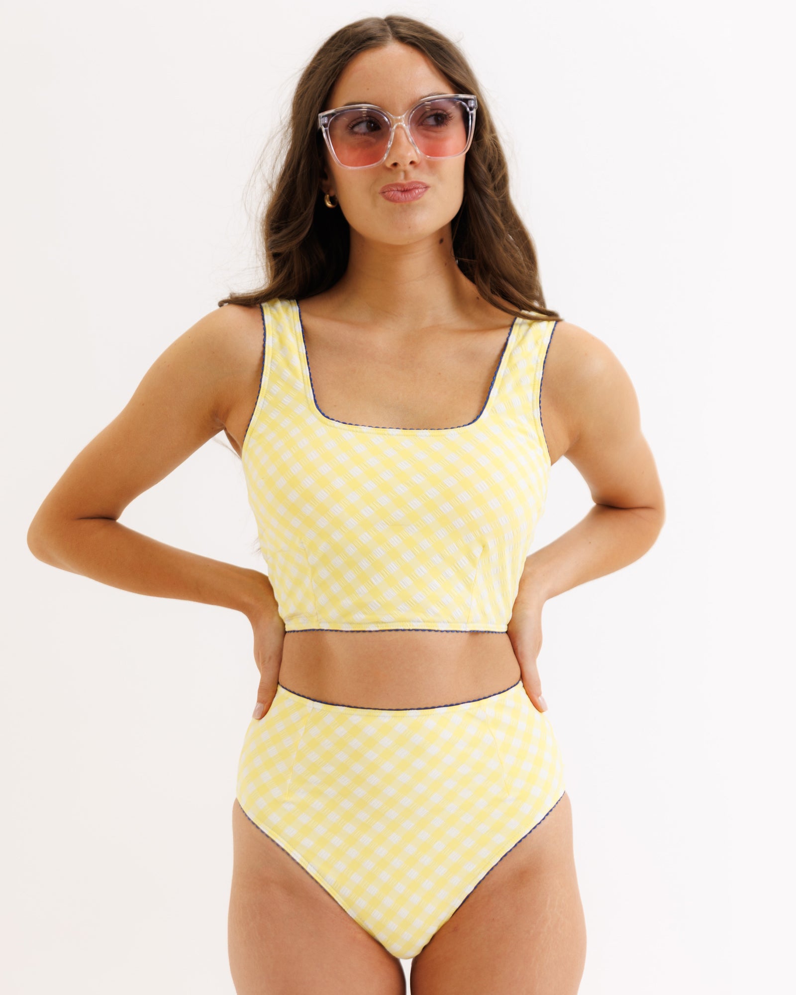 Woman wearing a yellow polka dot bikini set on a white background