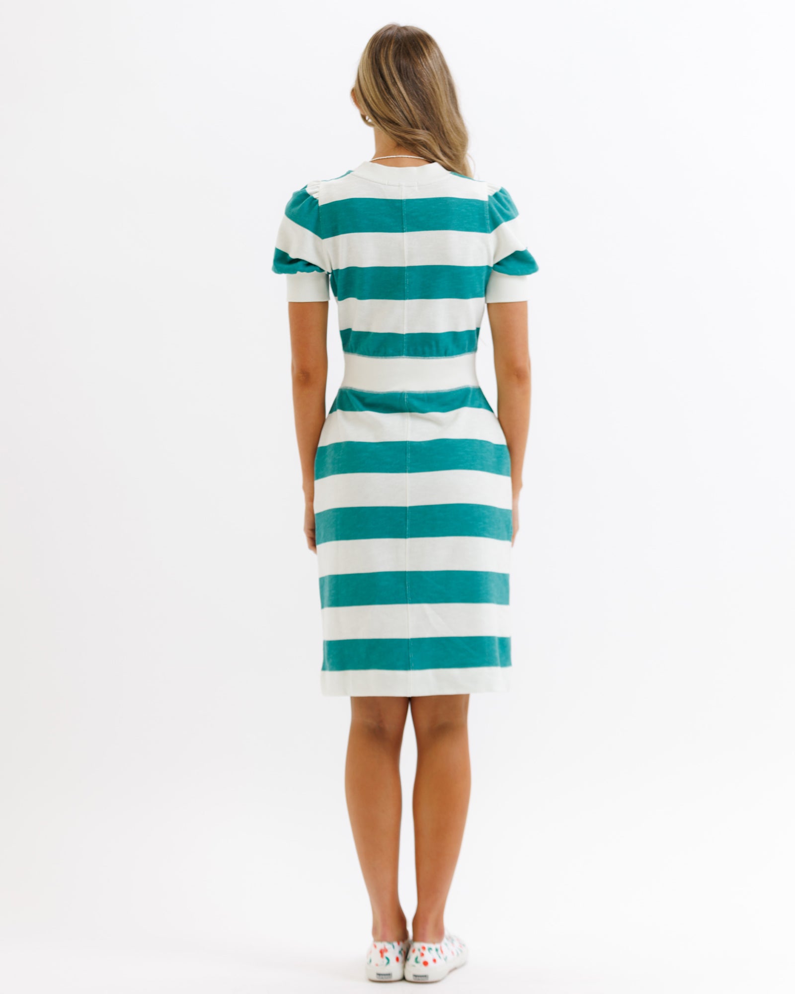 Woman wearing a green and white striped dress on a white background