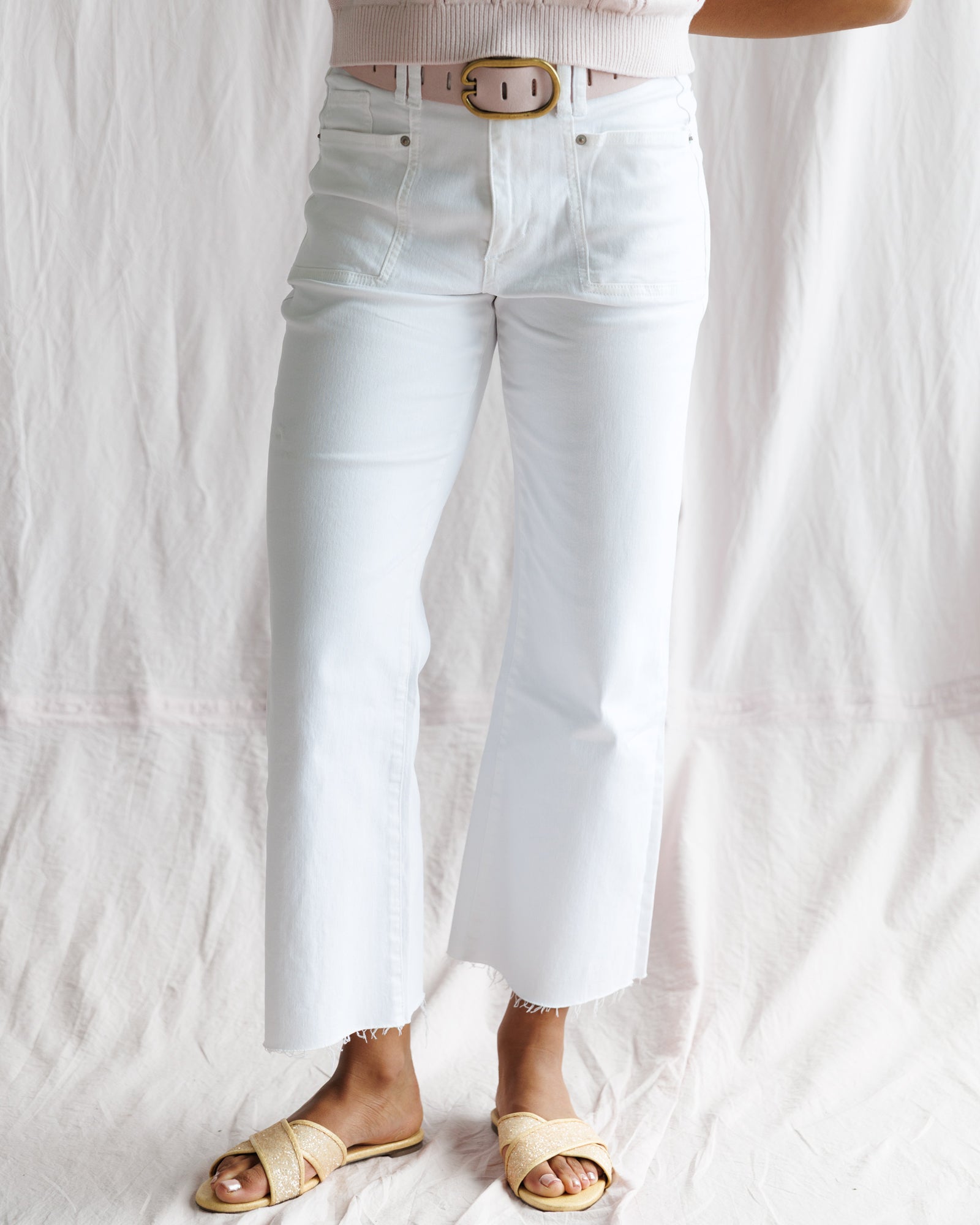 Person wearing light blue jeans with a white background