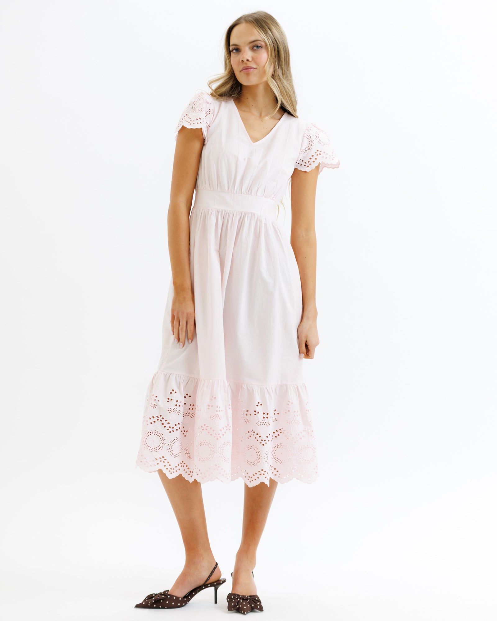 Woman wearing a pink lace dress on a white background