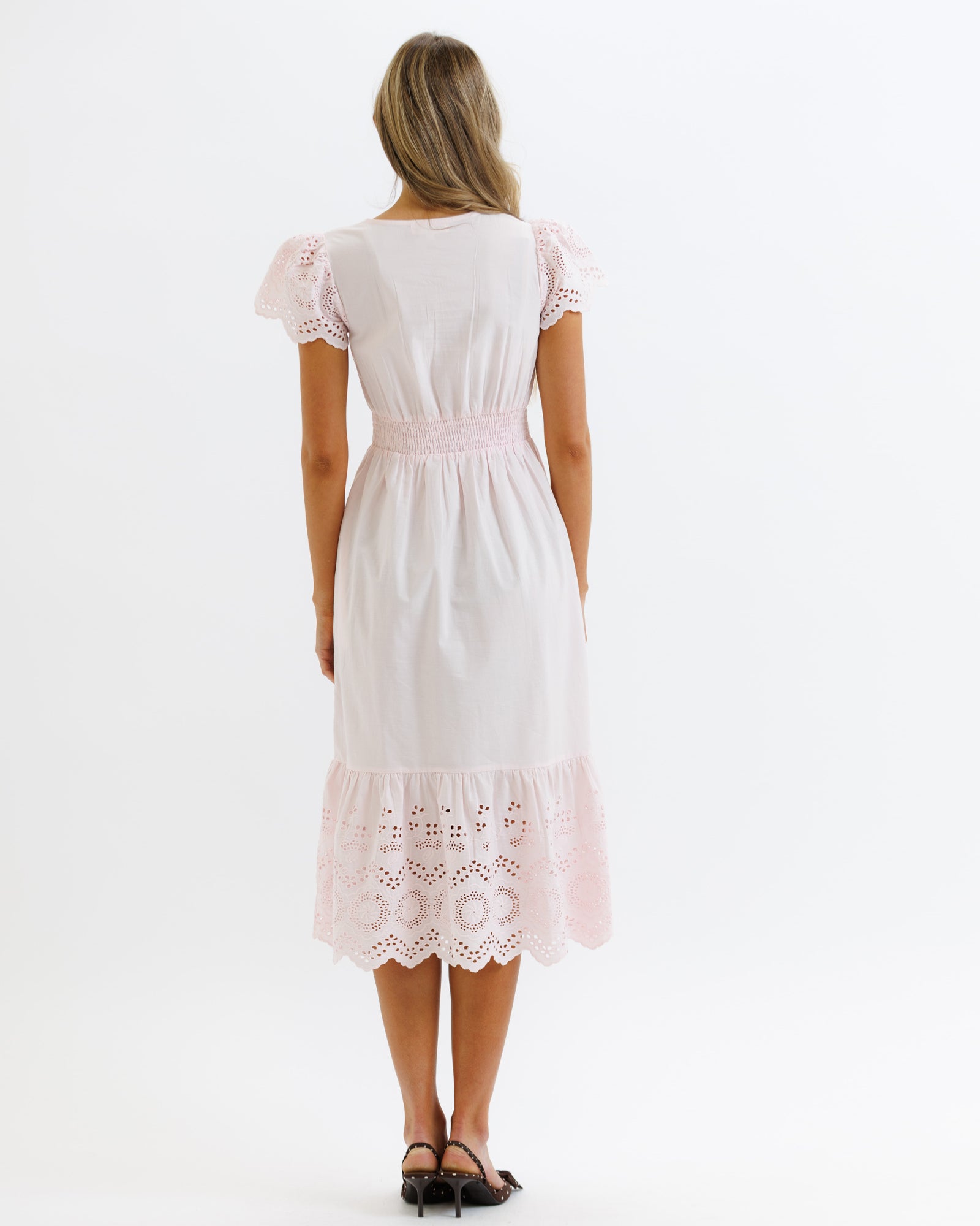 Pink dress with lace details on a white background