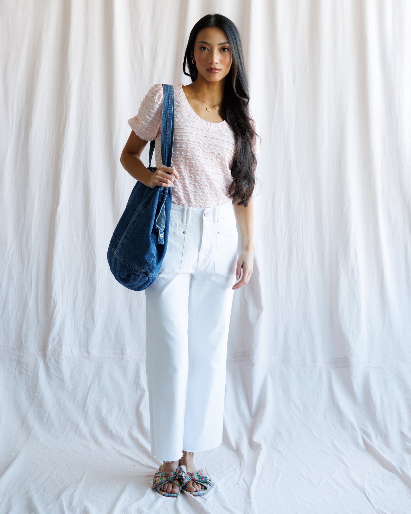 Woman holding a blue bag against a white background