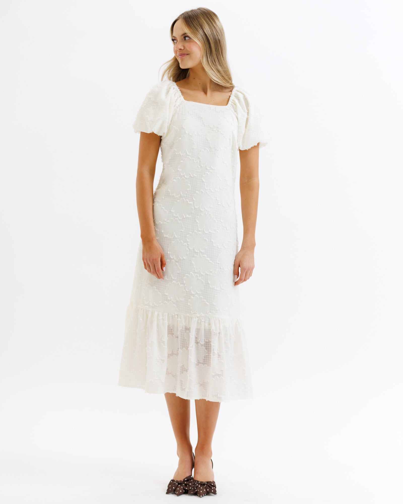Woman wearing a white lace dress on a white background