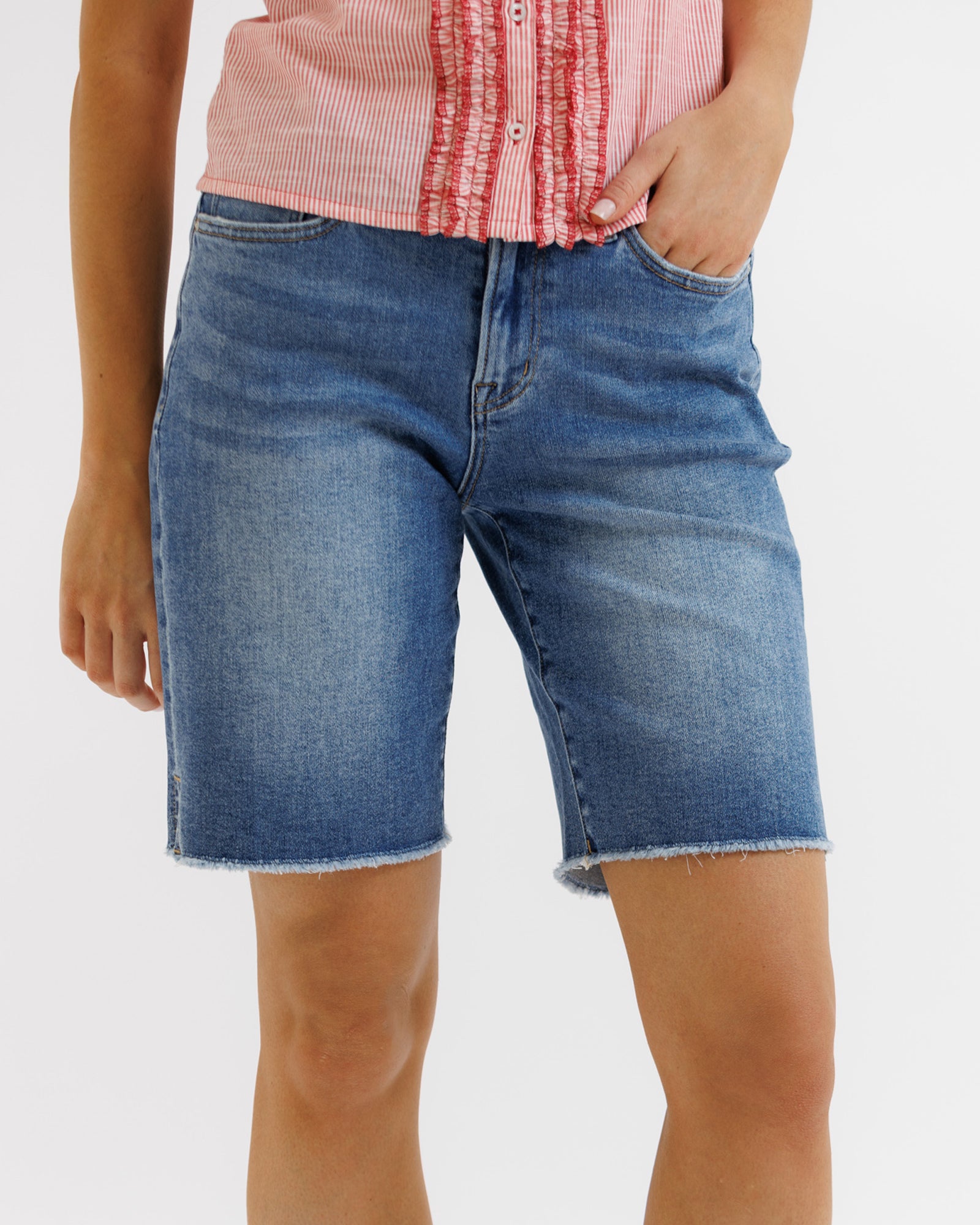 Person wearing blue denim shorts on a white background