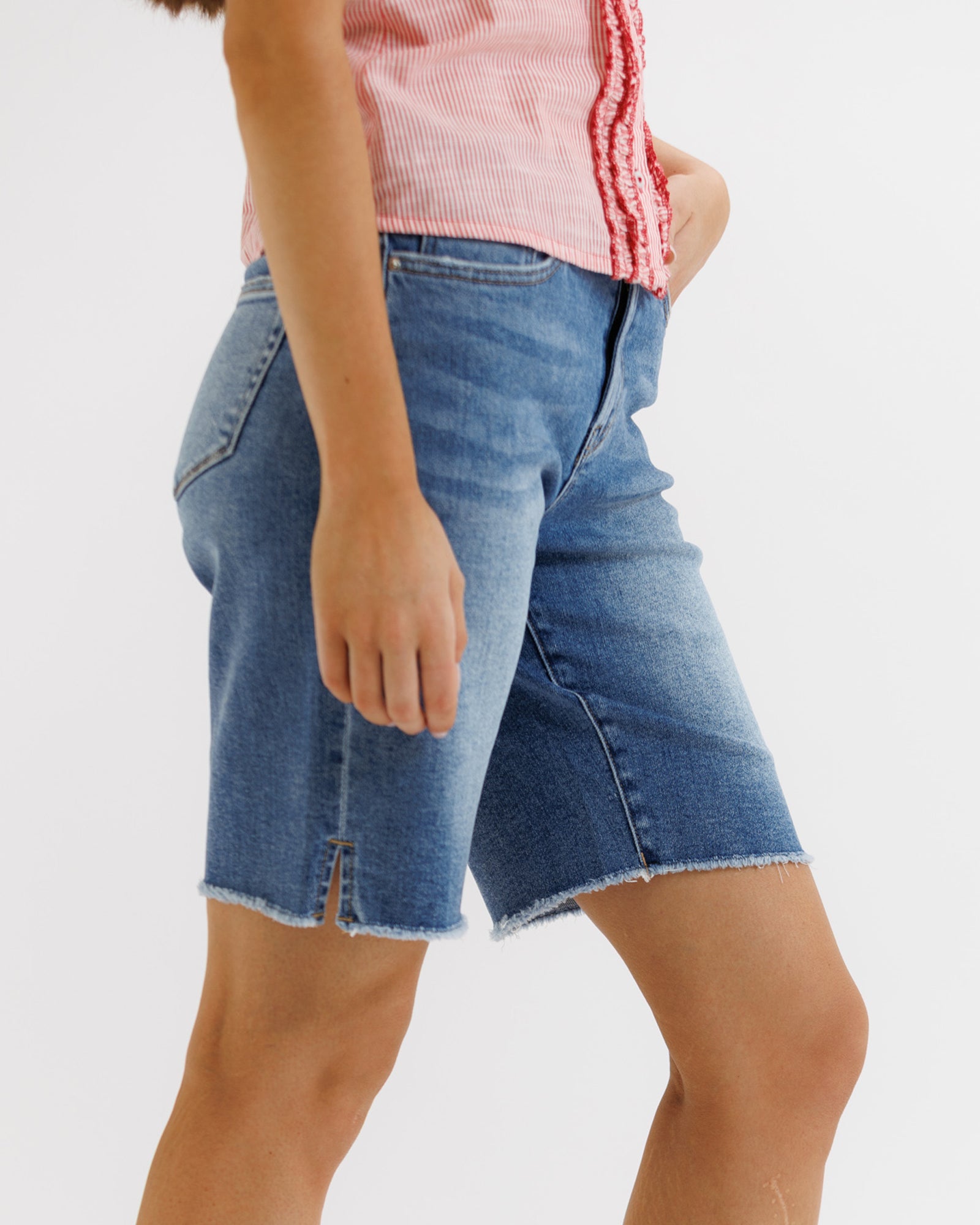 Person wearing blue denim shorts on a white background