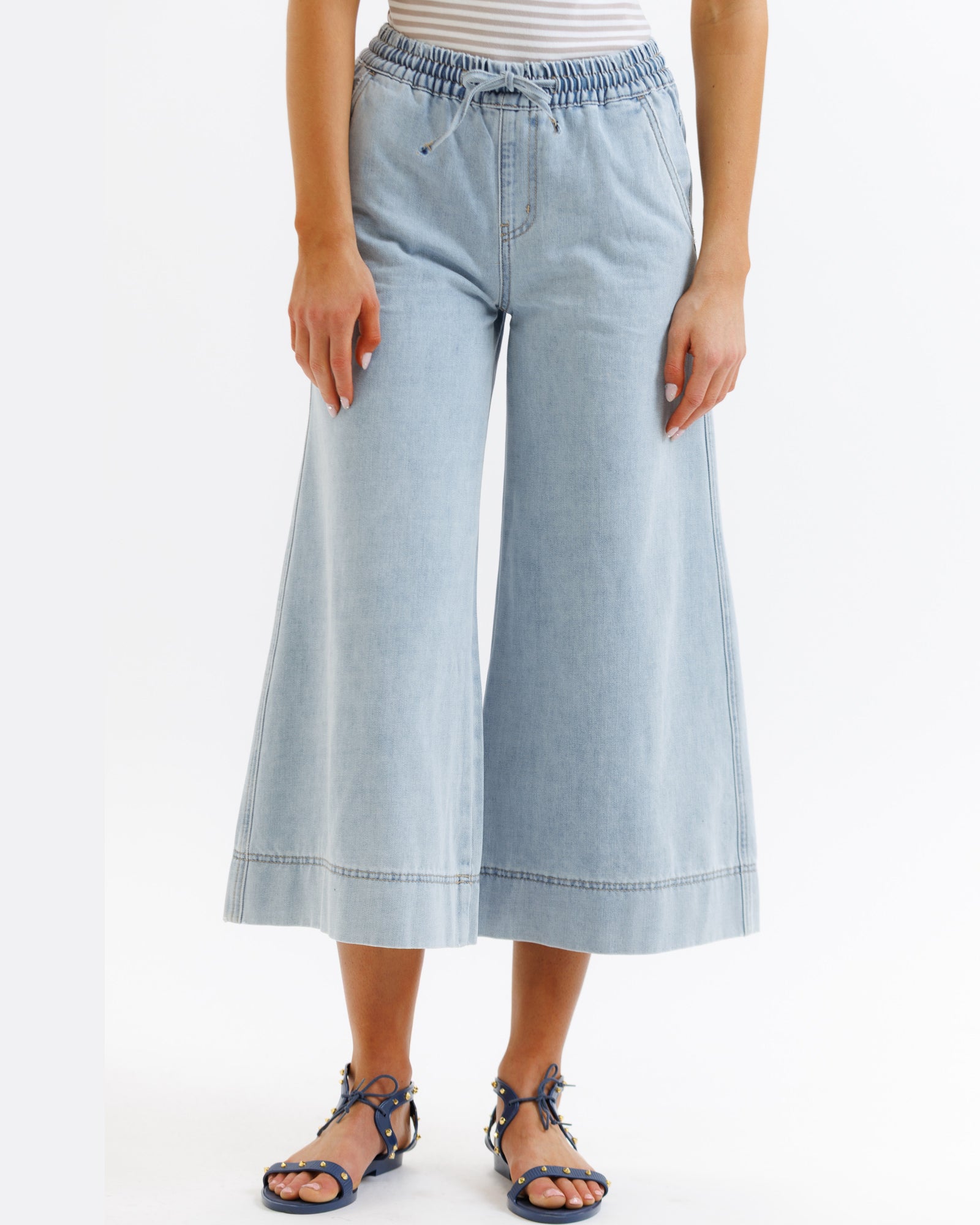 Light blue denim culottes worn by a person on a white background