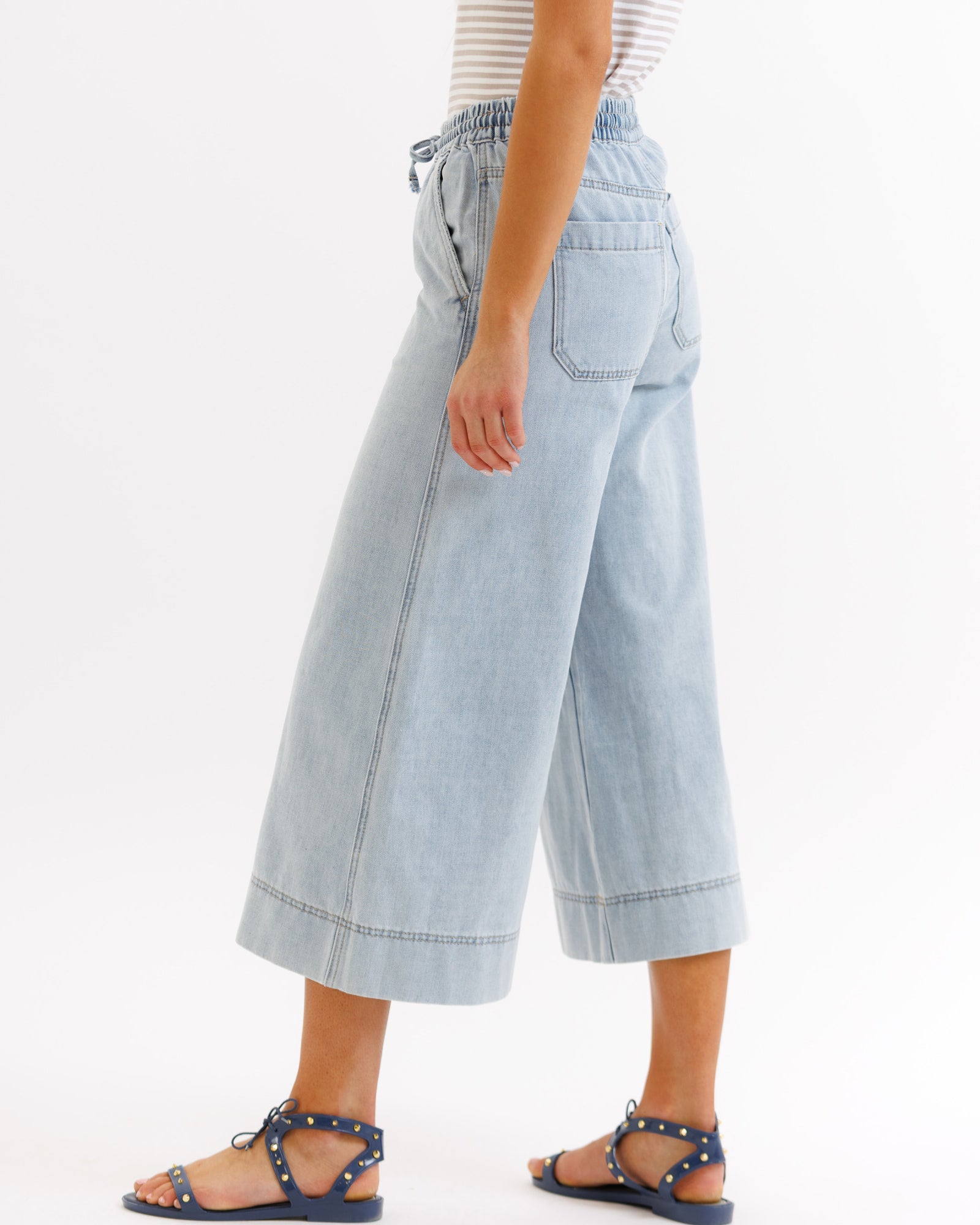 Light blue denim wide-leg pants worn by a person on a white background