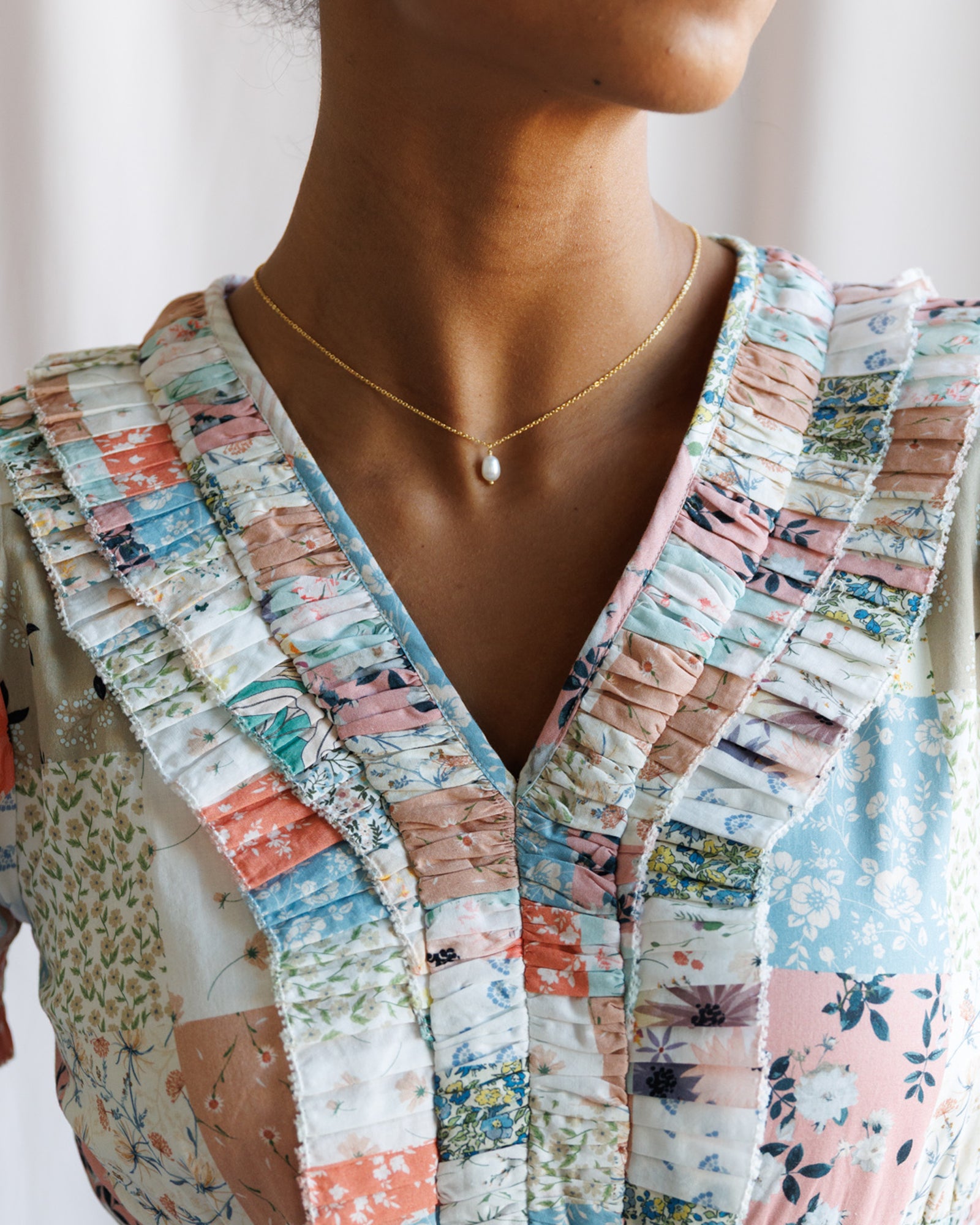 Person wearing a colorful patchwork jacket with a blurred background