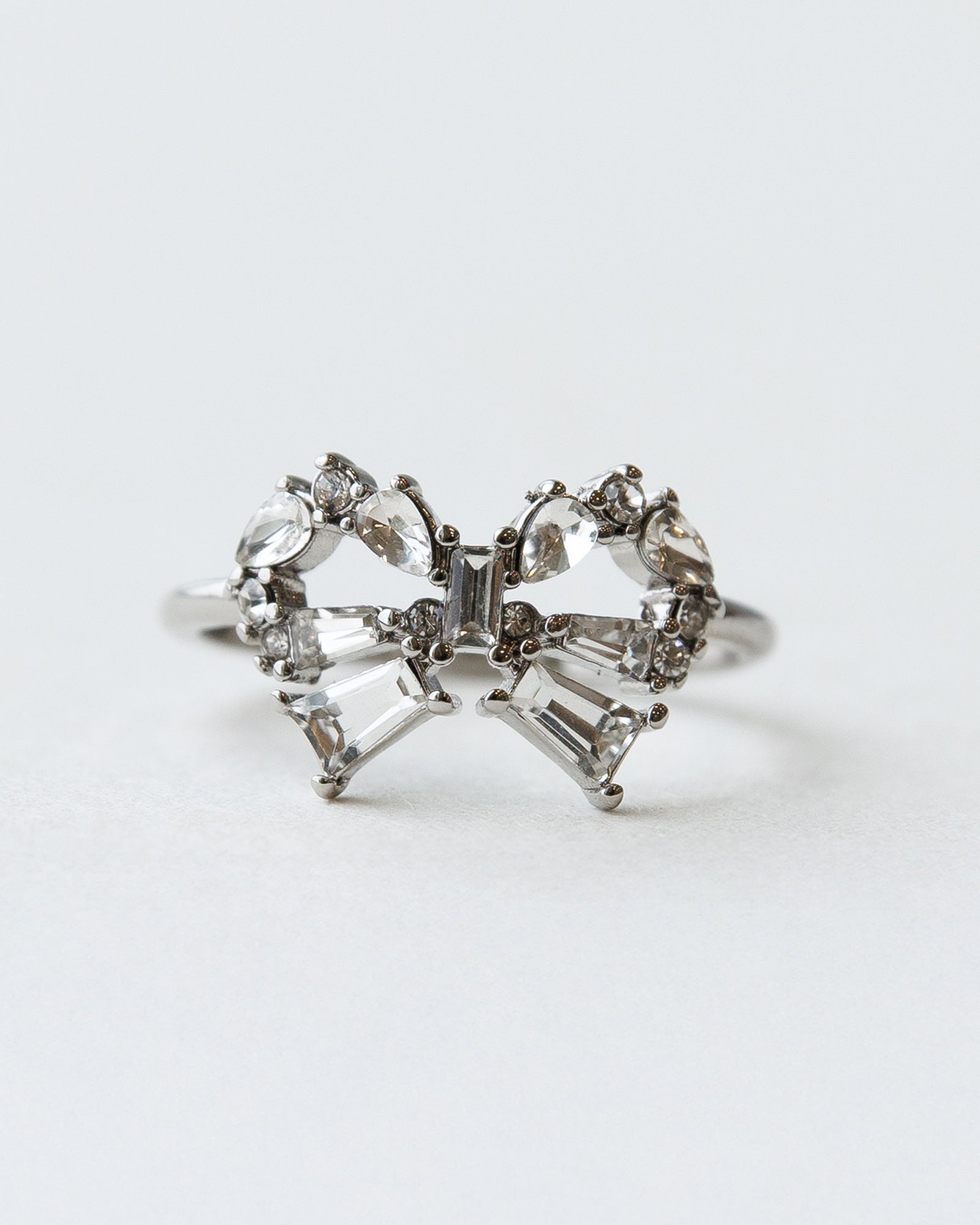 Diamond butterfly ring on a light gray background