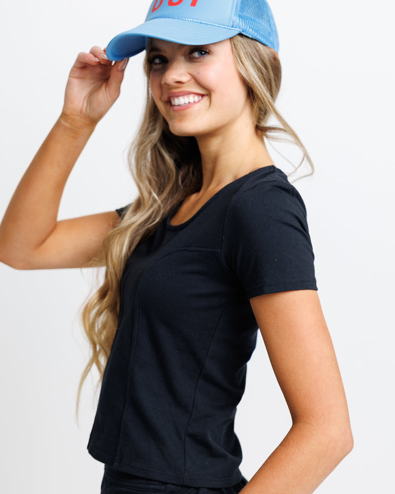 Model wearing a black short sleeve scoop neck tee