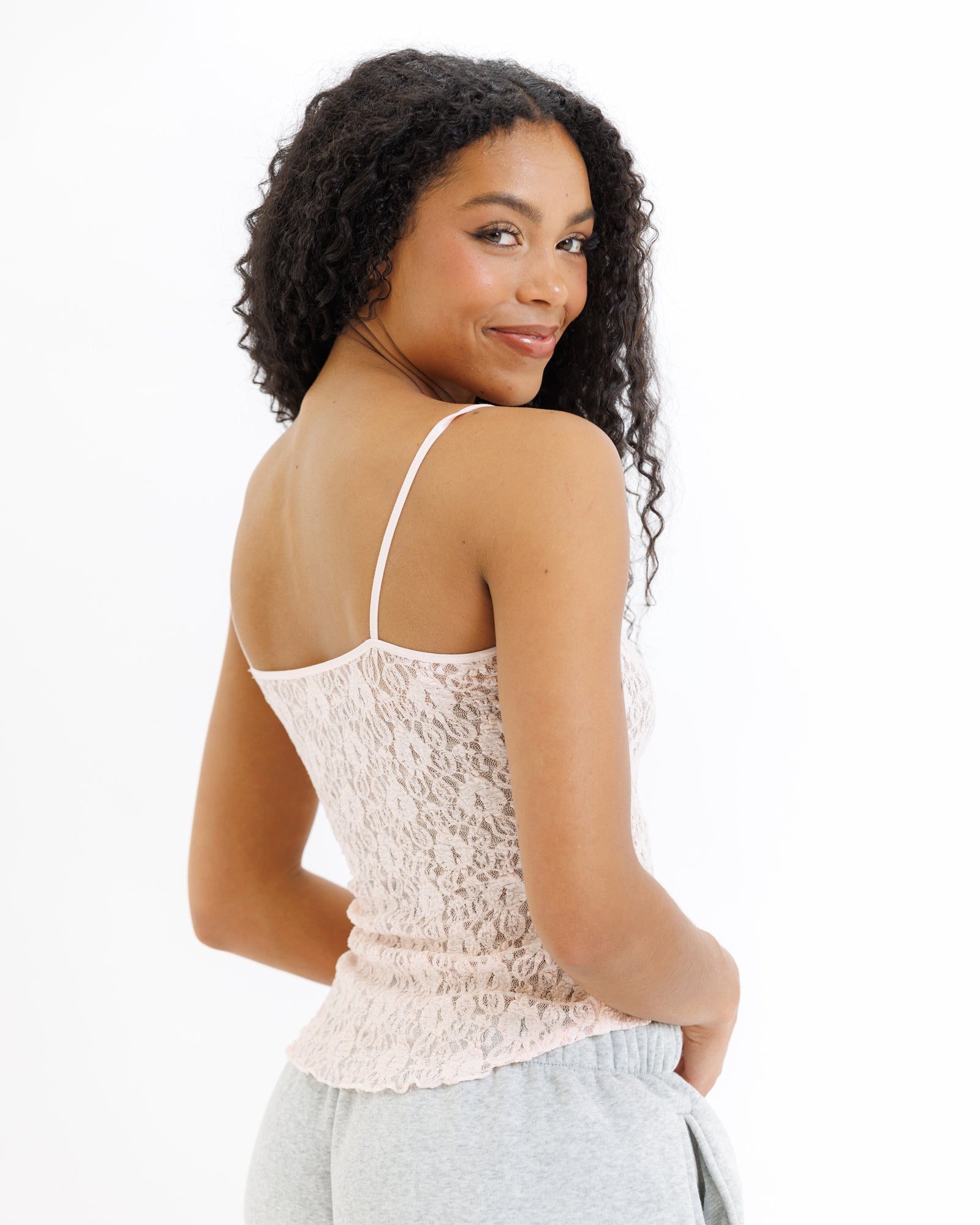 Woman wearing a lace top with thin straps on a white background