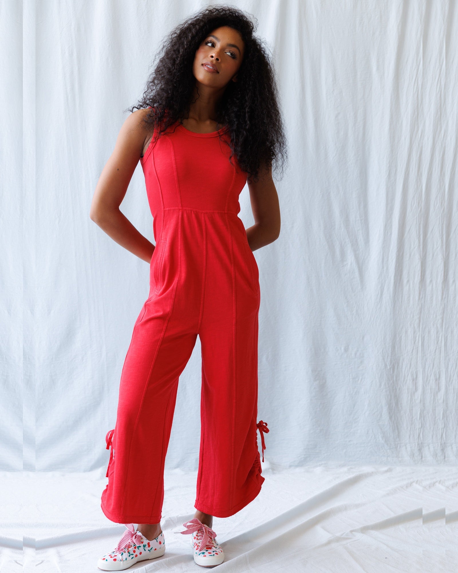 Woman wearing a red jumpsuit against a white background