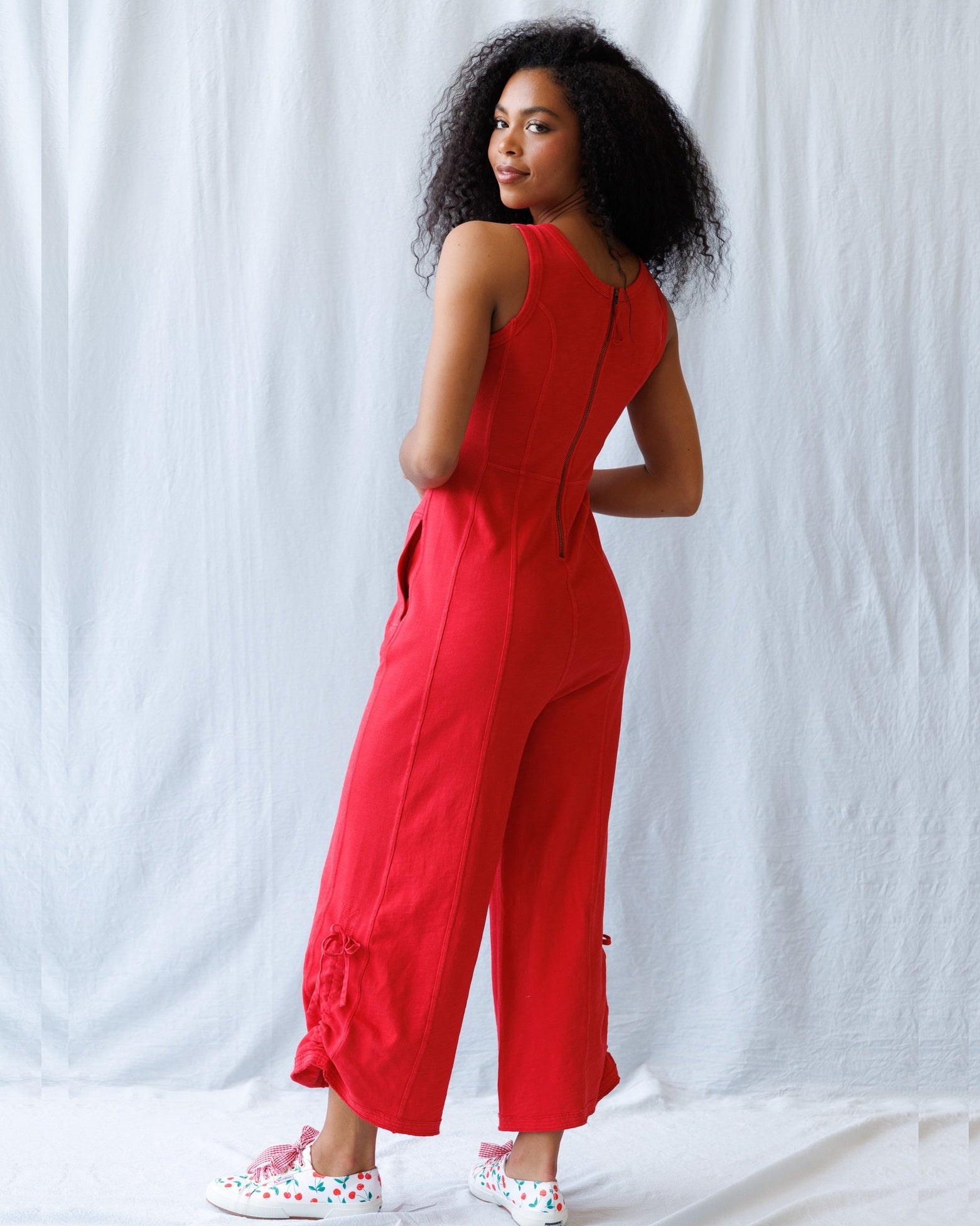 Woman wearing a red jumpsuit against a white background