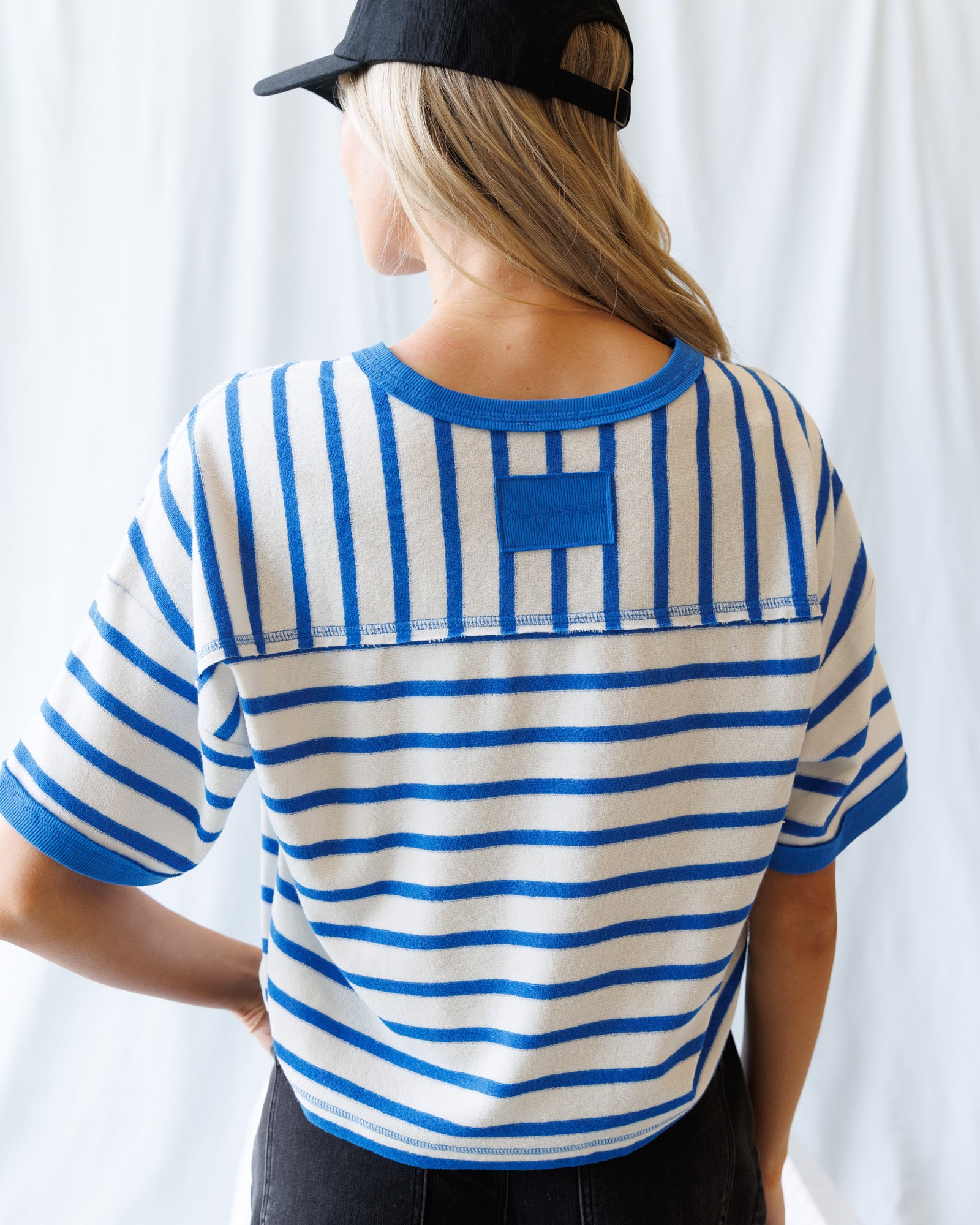 Person wearing a blue and white striped shirt with a logo on a white background