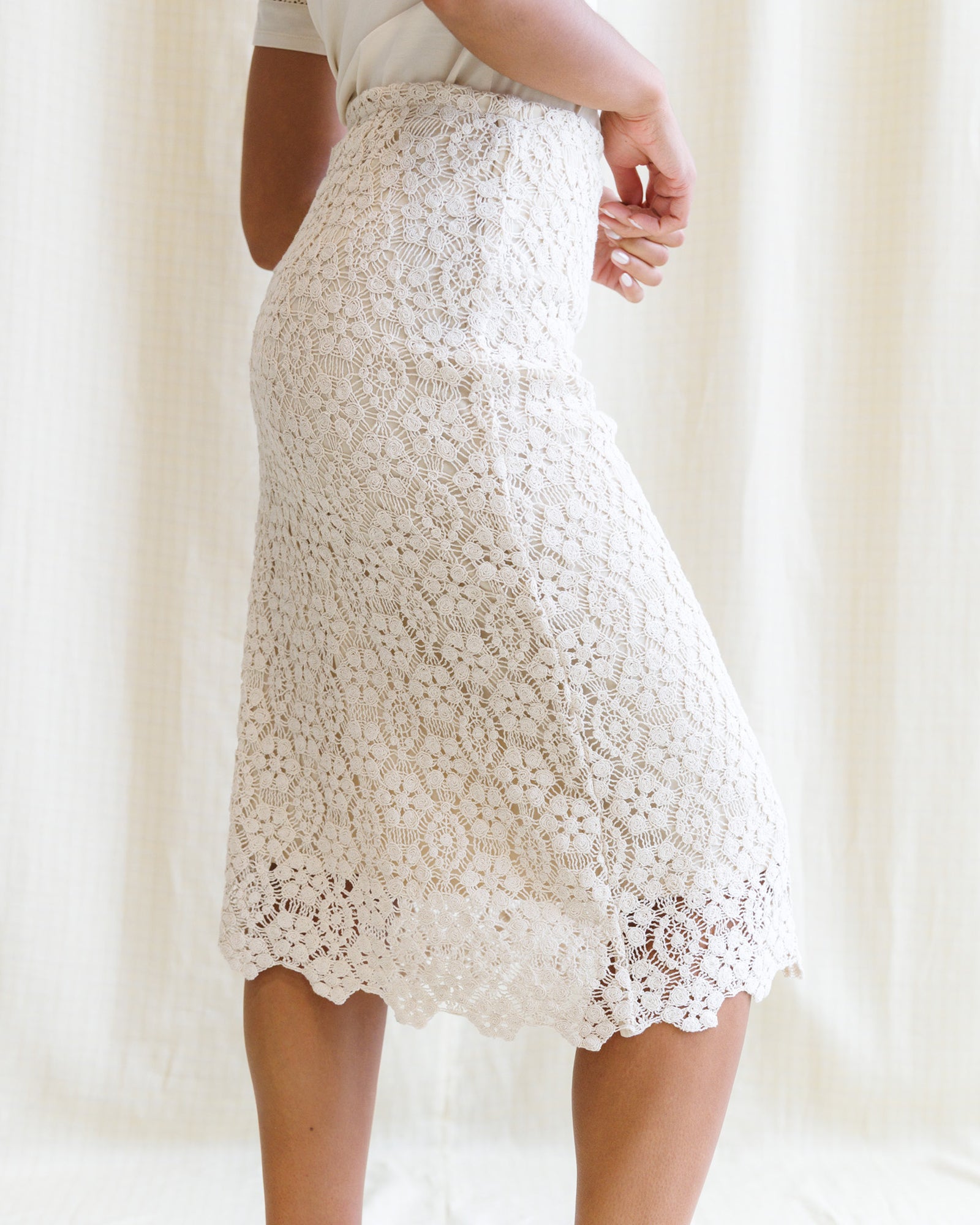 White lace skirt worn by a person against a white background