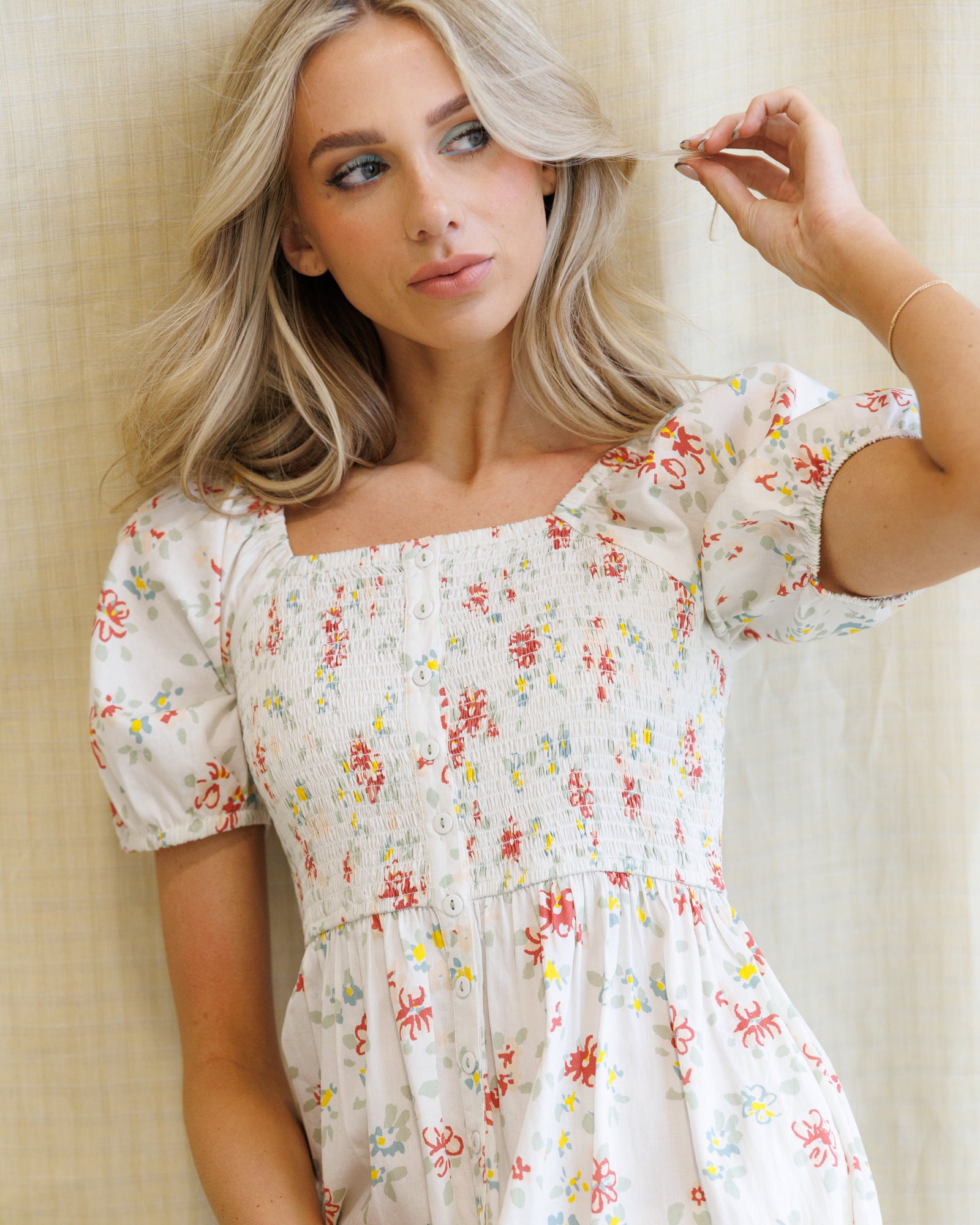 Woman wearing a floral dress against a neutral background