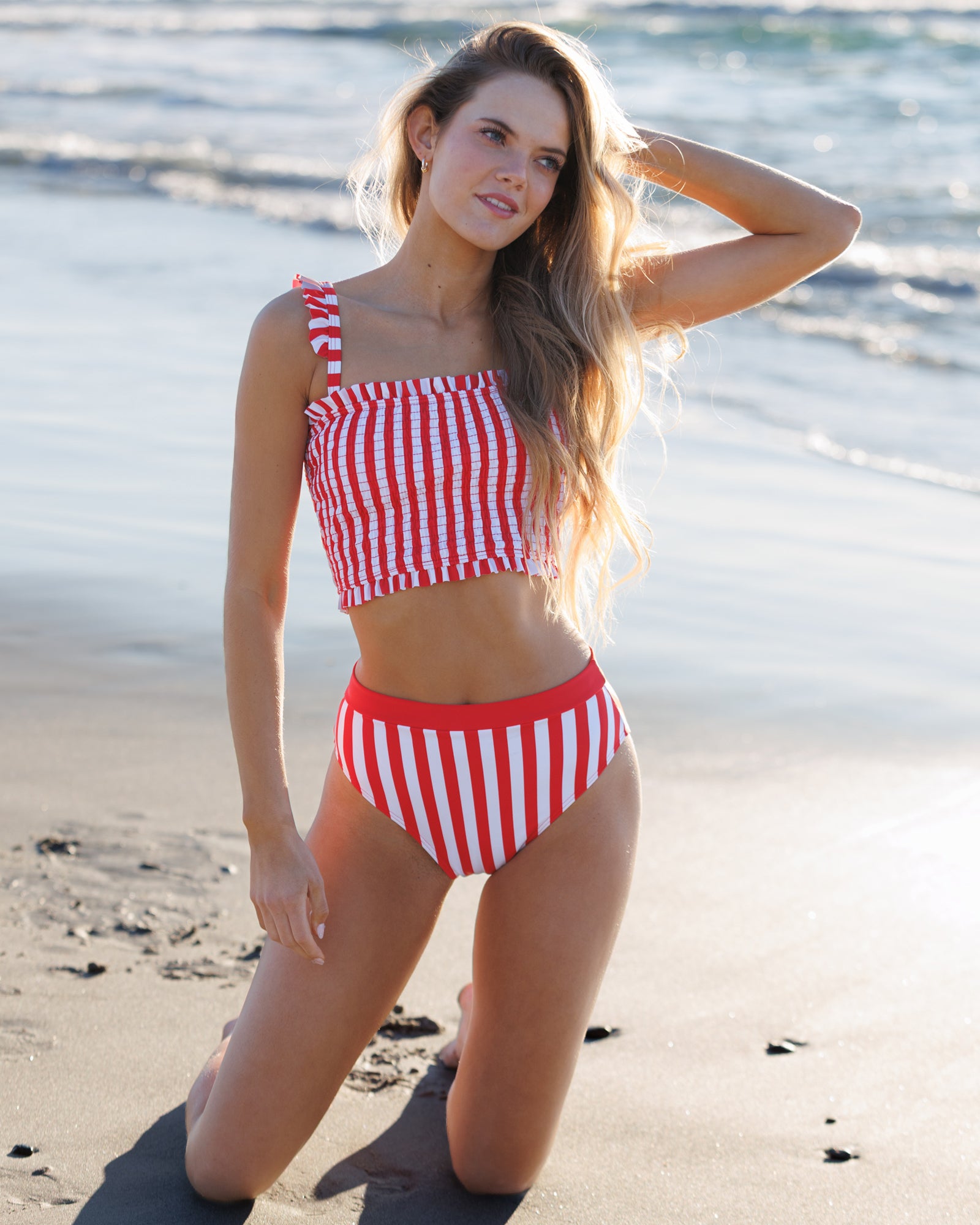 Woman wearing a red and white striped bikini on a beach