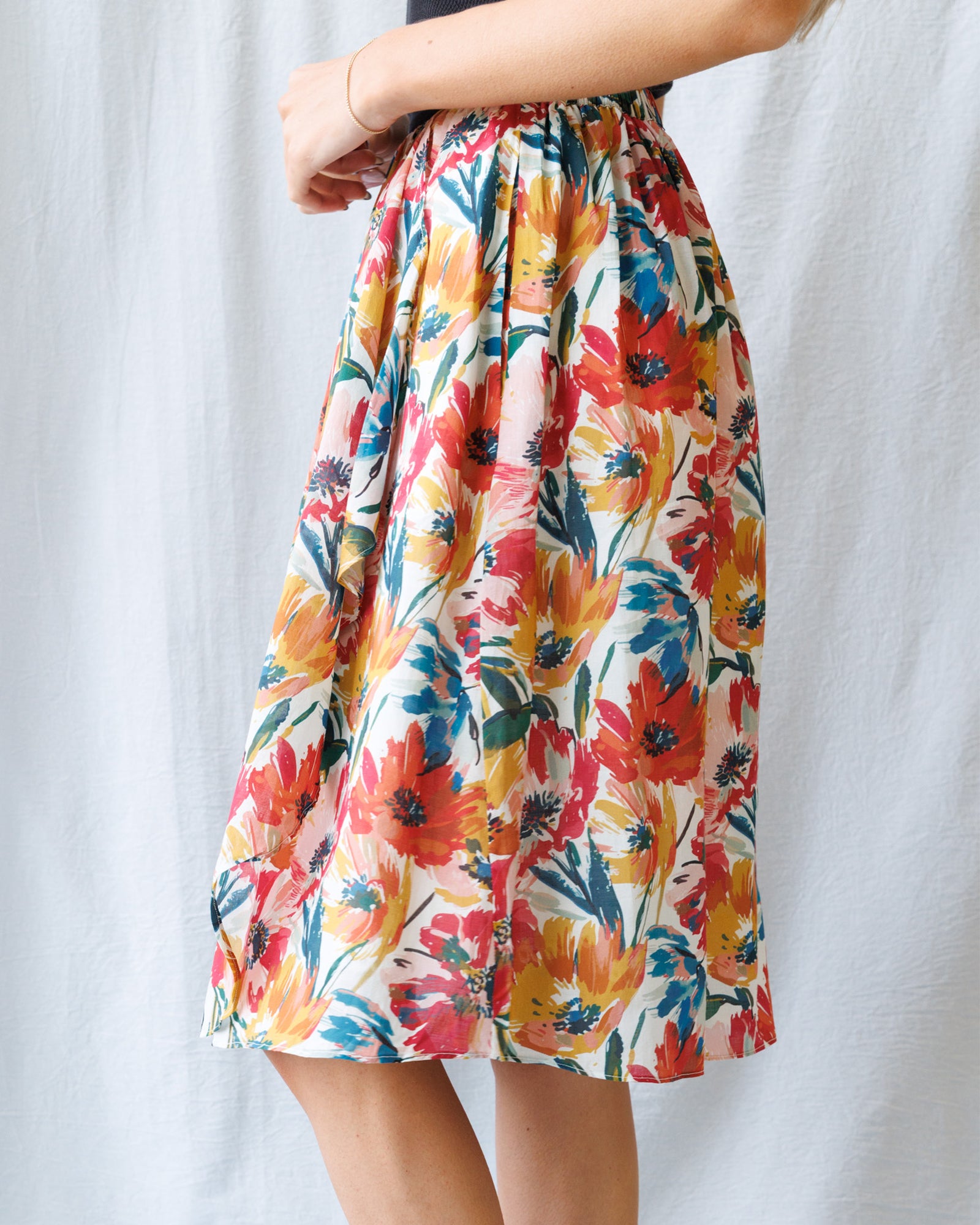 Colorful floral skirt worn by a person on a white background