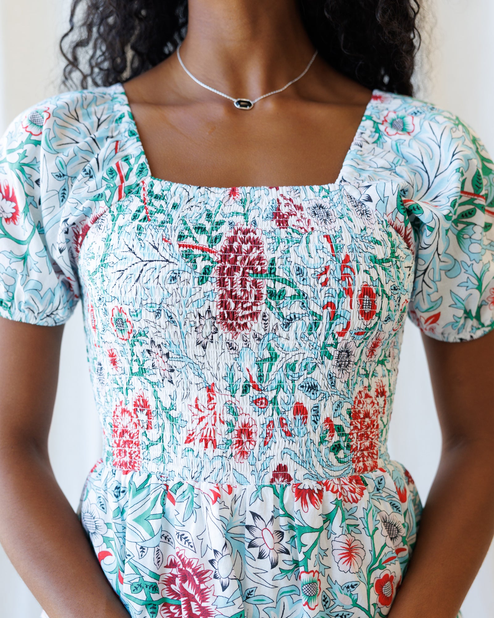 Woman wearing a floral dress with a white background