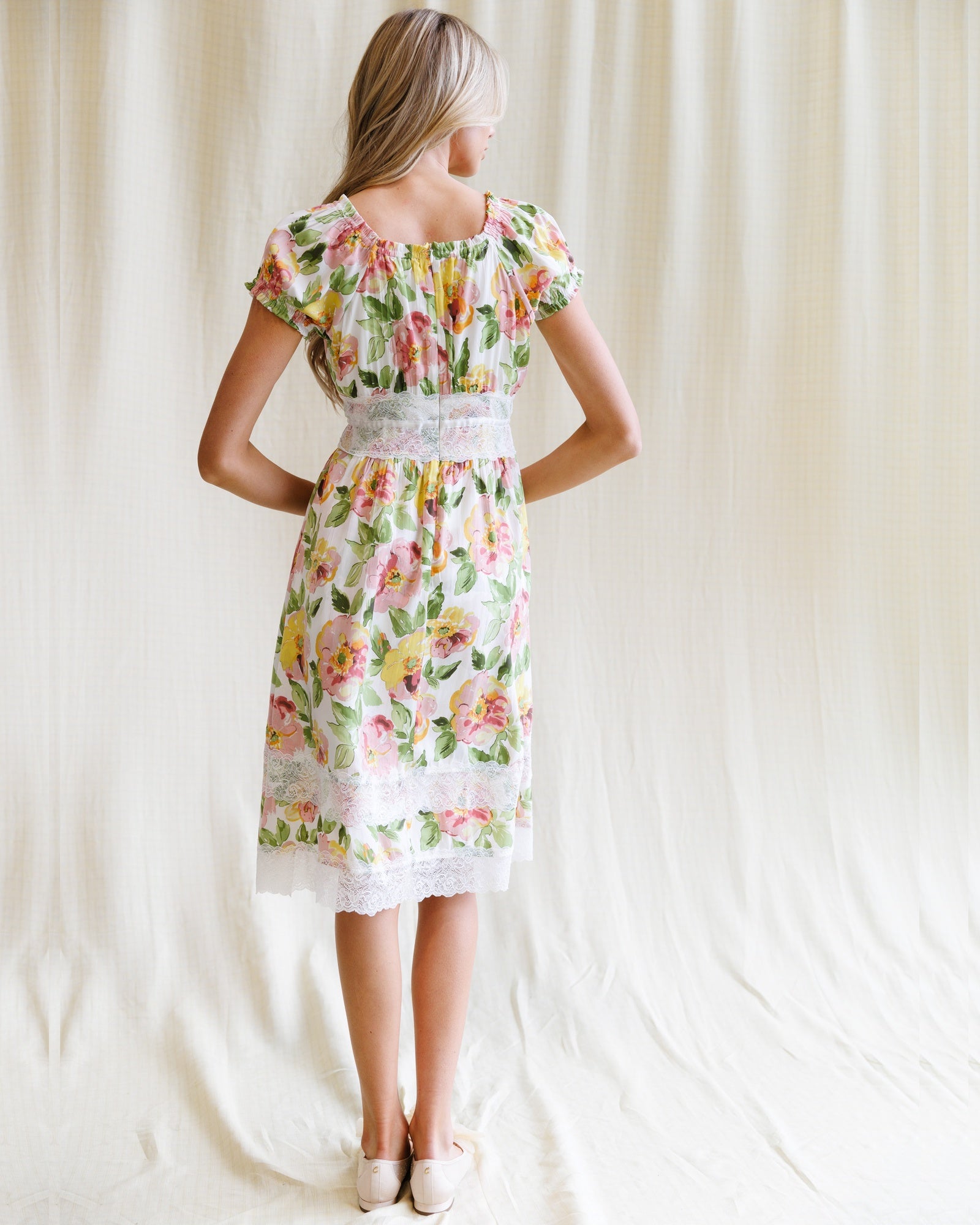 Woman wearing a floral dress against a plain background