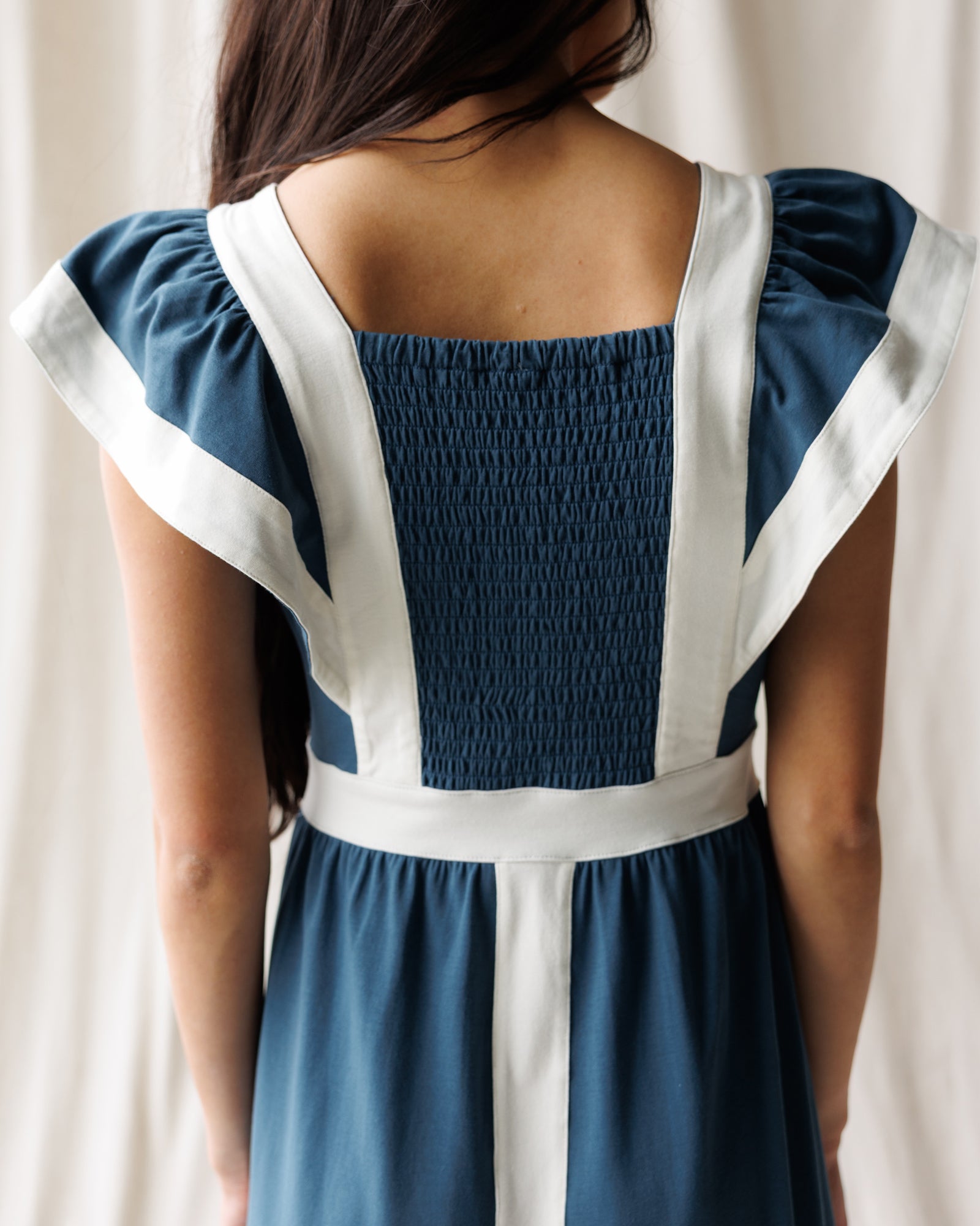 Woman wearing a blue and white dress with smocked back