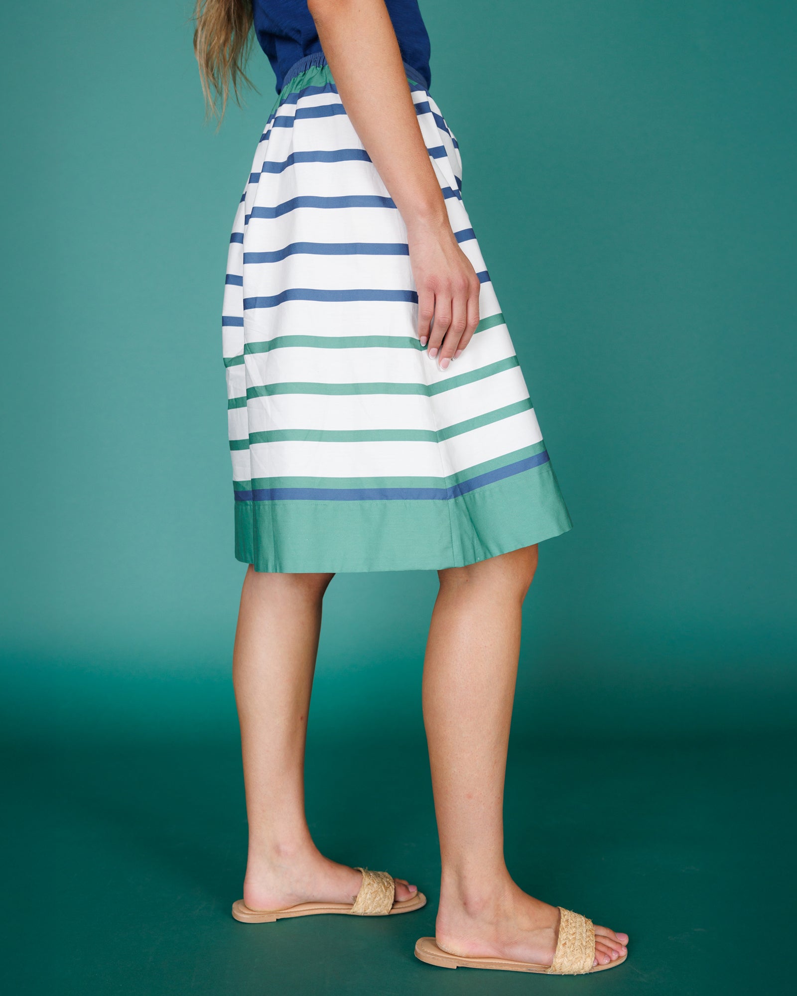 Person wearing a striped skirt with green background