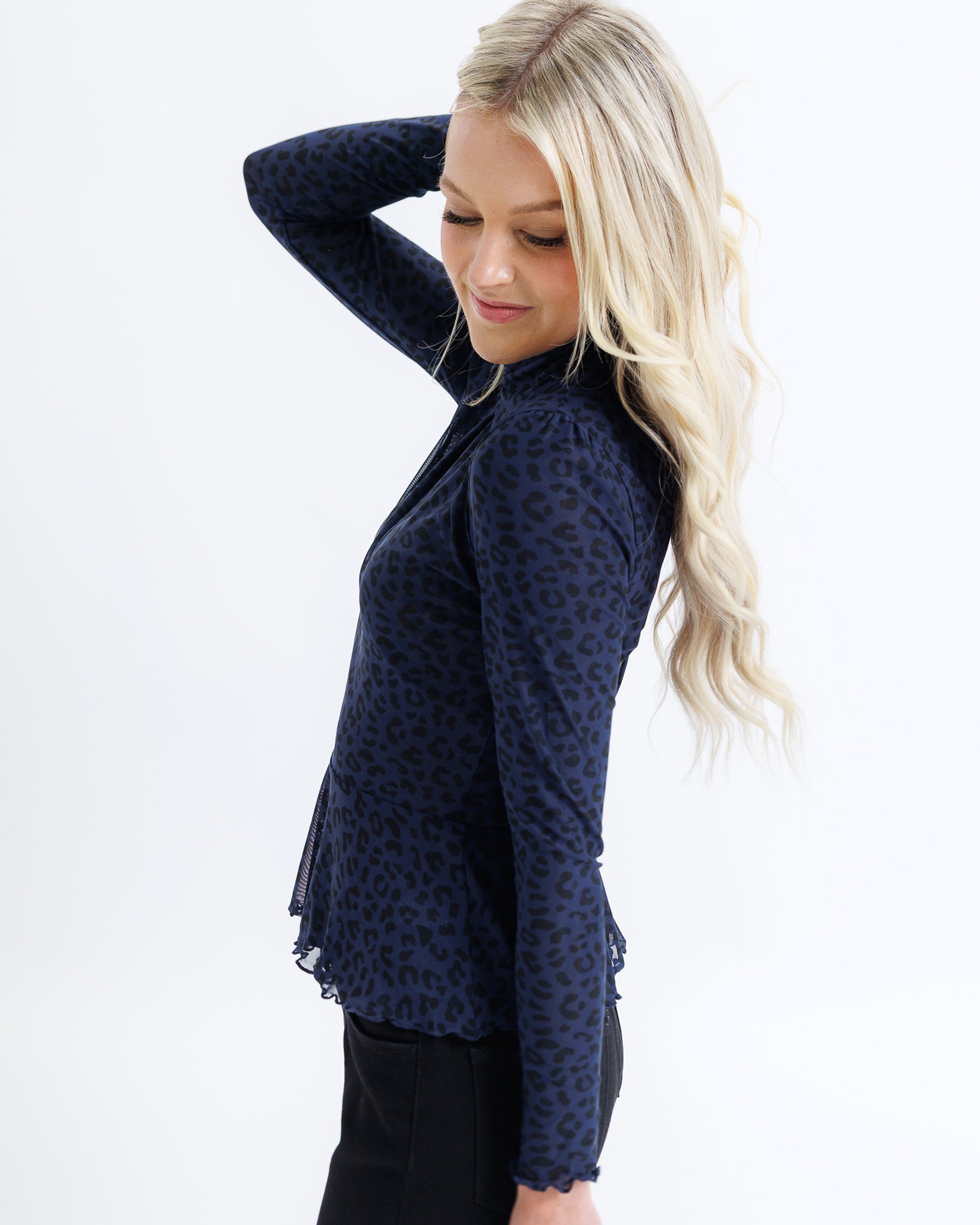 Woman wearing a navy blue patterned top on a white background