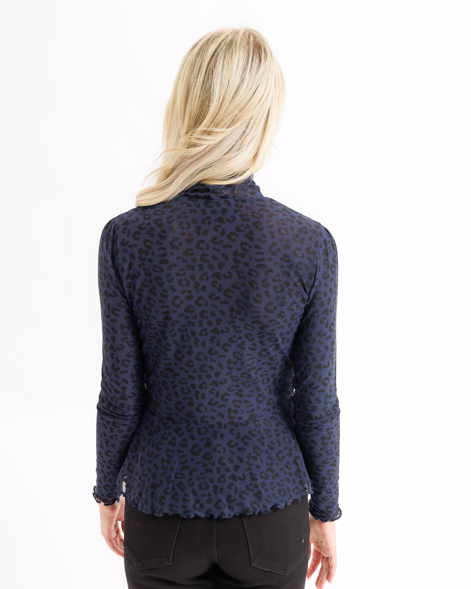 Navy blue patterned blouse worn by a person on a white background