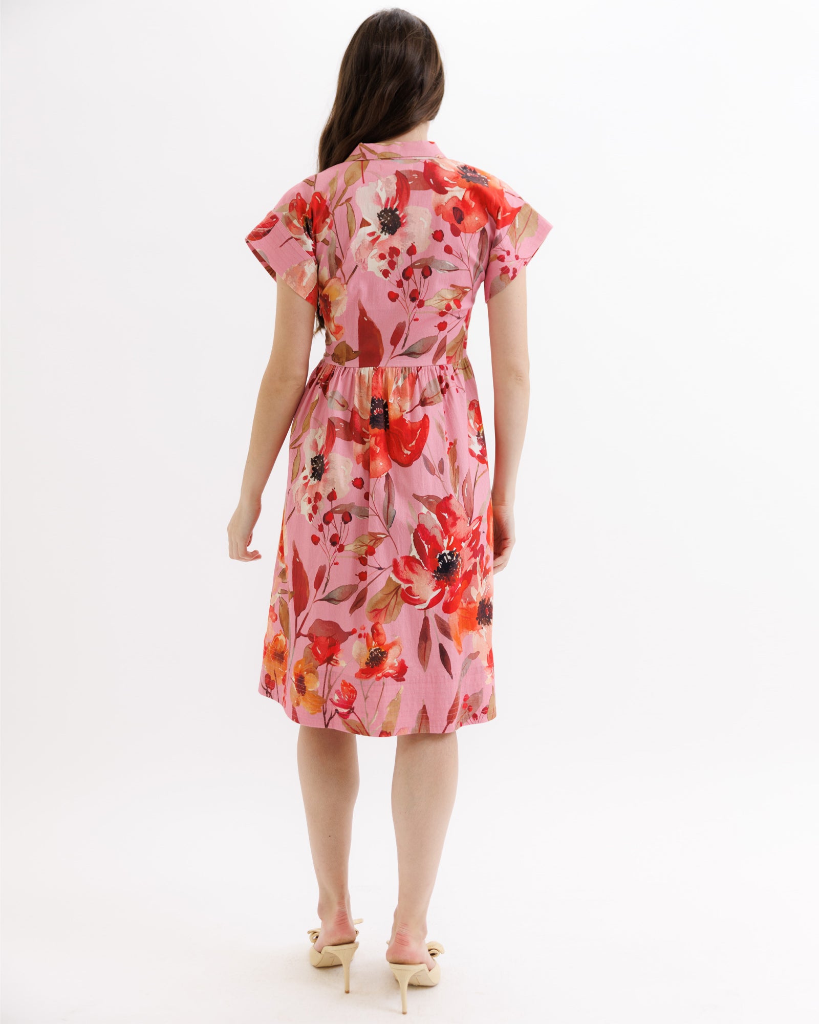 Woman wearing a pink floral dress on a white background