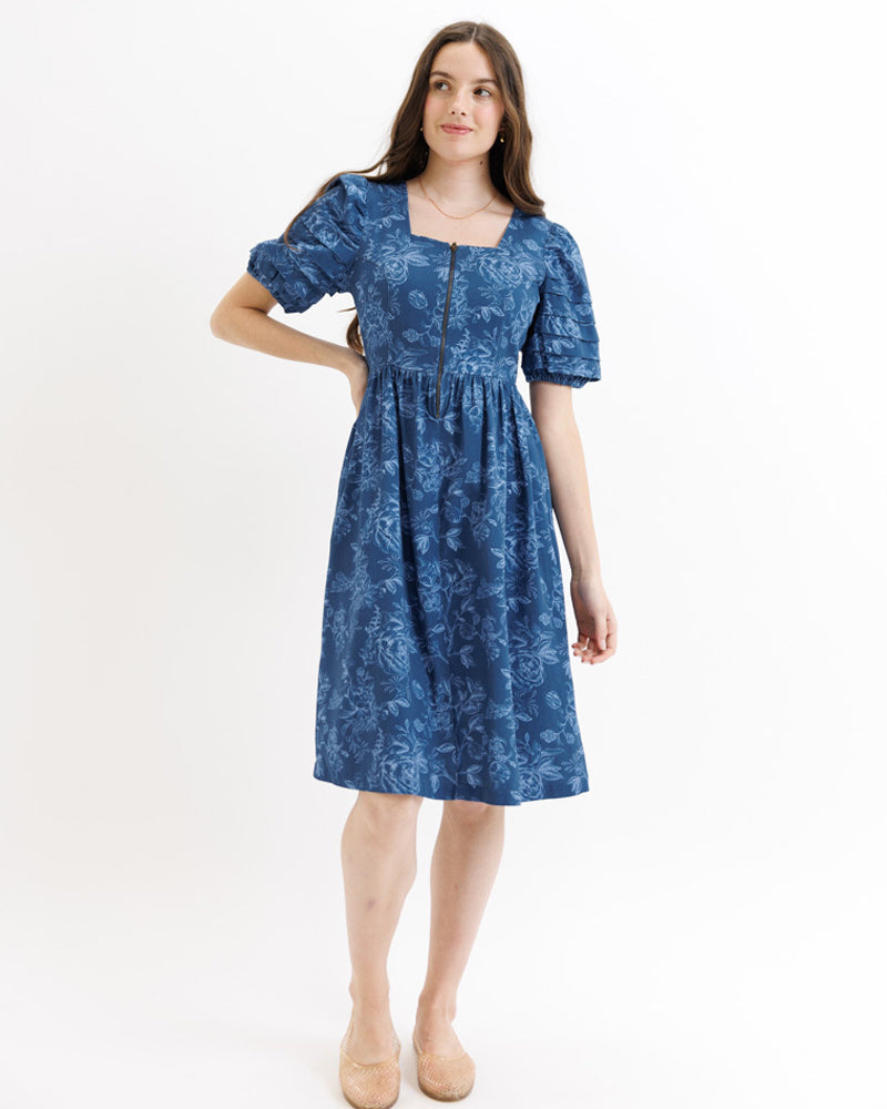 Woman wearing a blue floral dress on a white background
