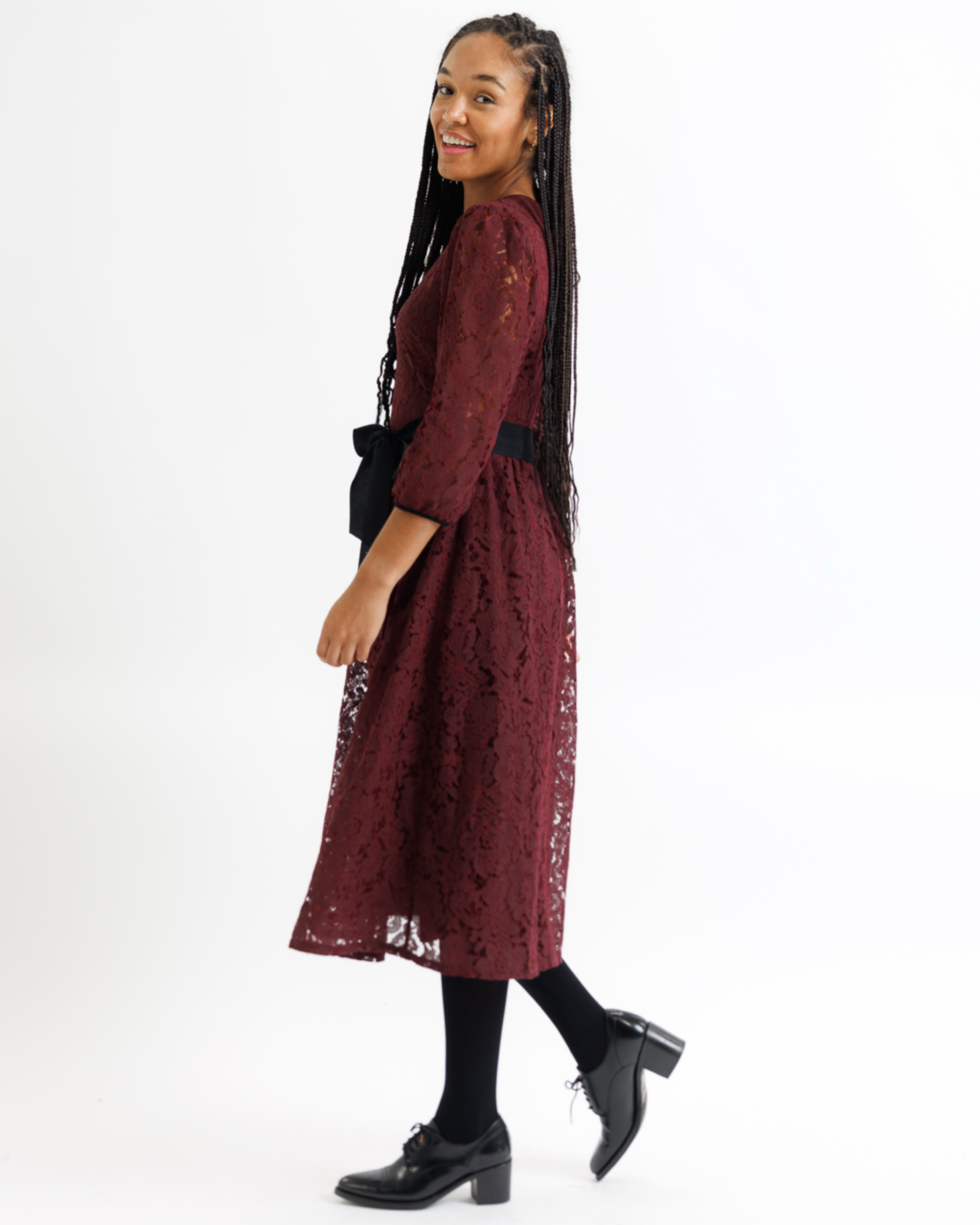 Woman wearing a burgundy lace dress on a white background