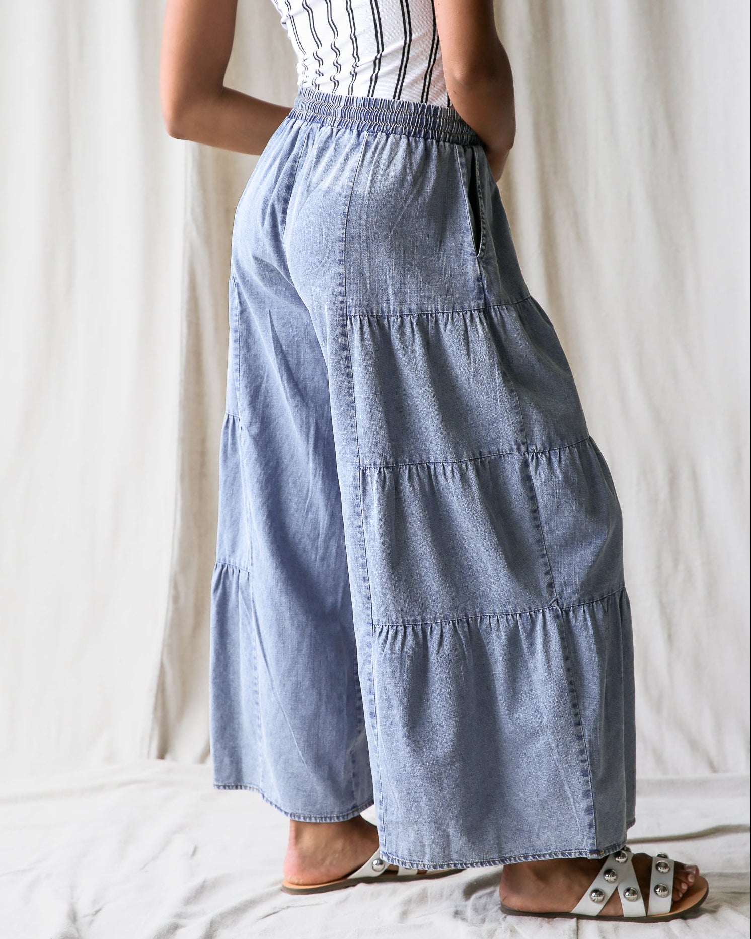 Person wearing a light blue tiered skirt against a white background