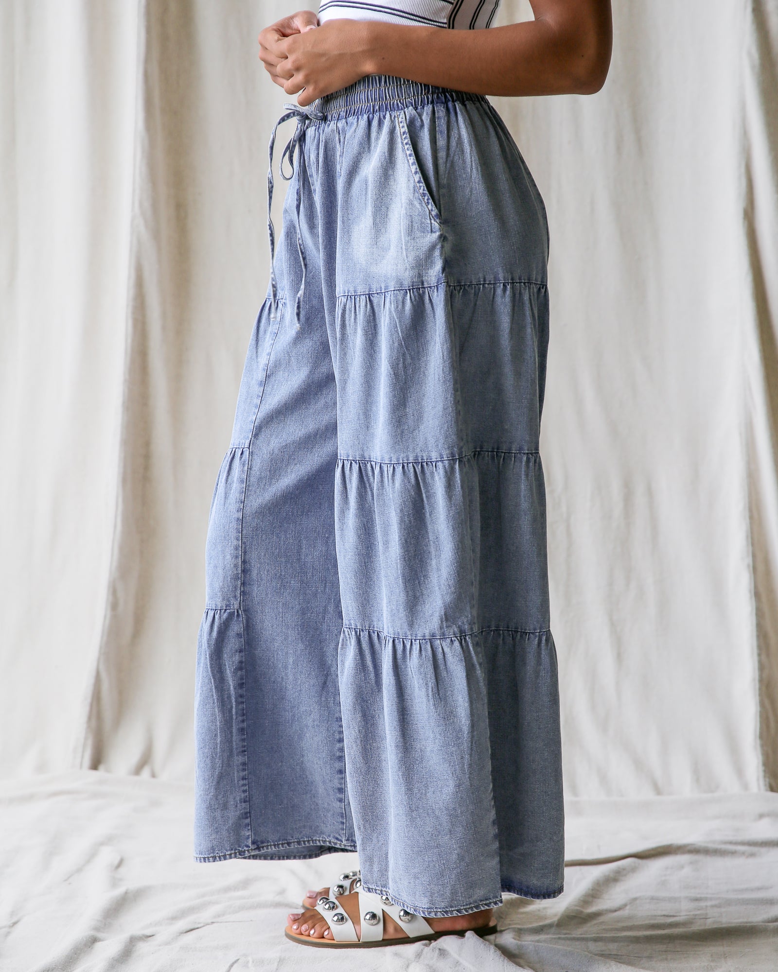Blue tiered skirt worn by a person on a neutral background