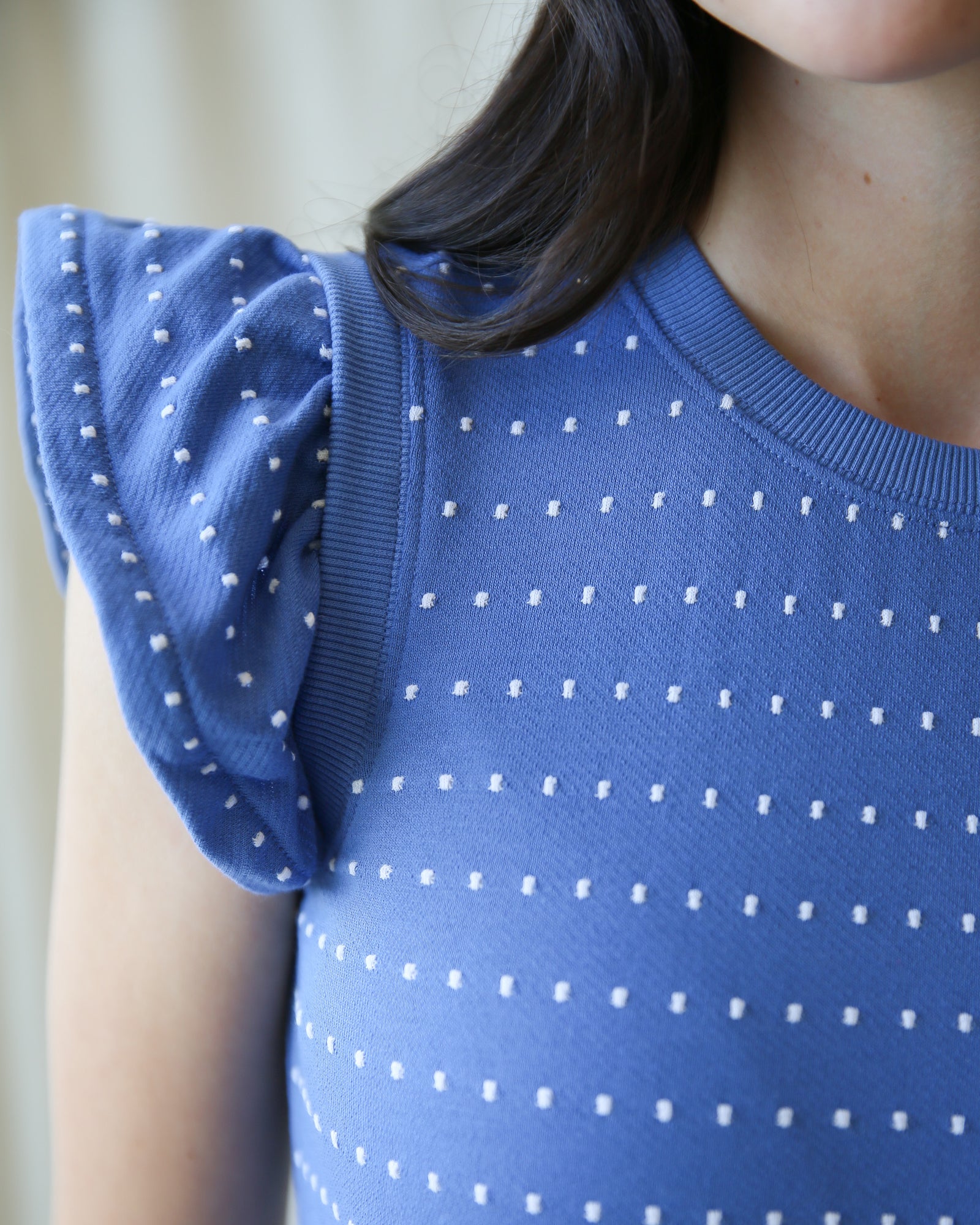 Blue polka dot dress with short sleeves worn by a person.