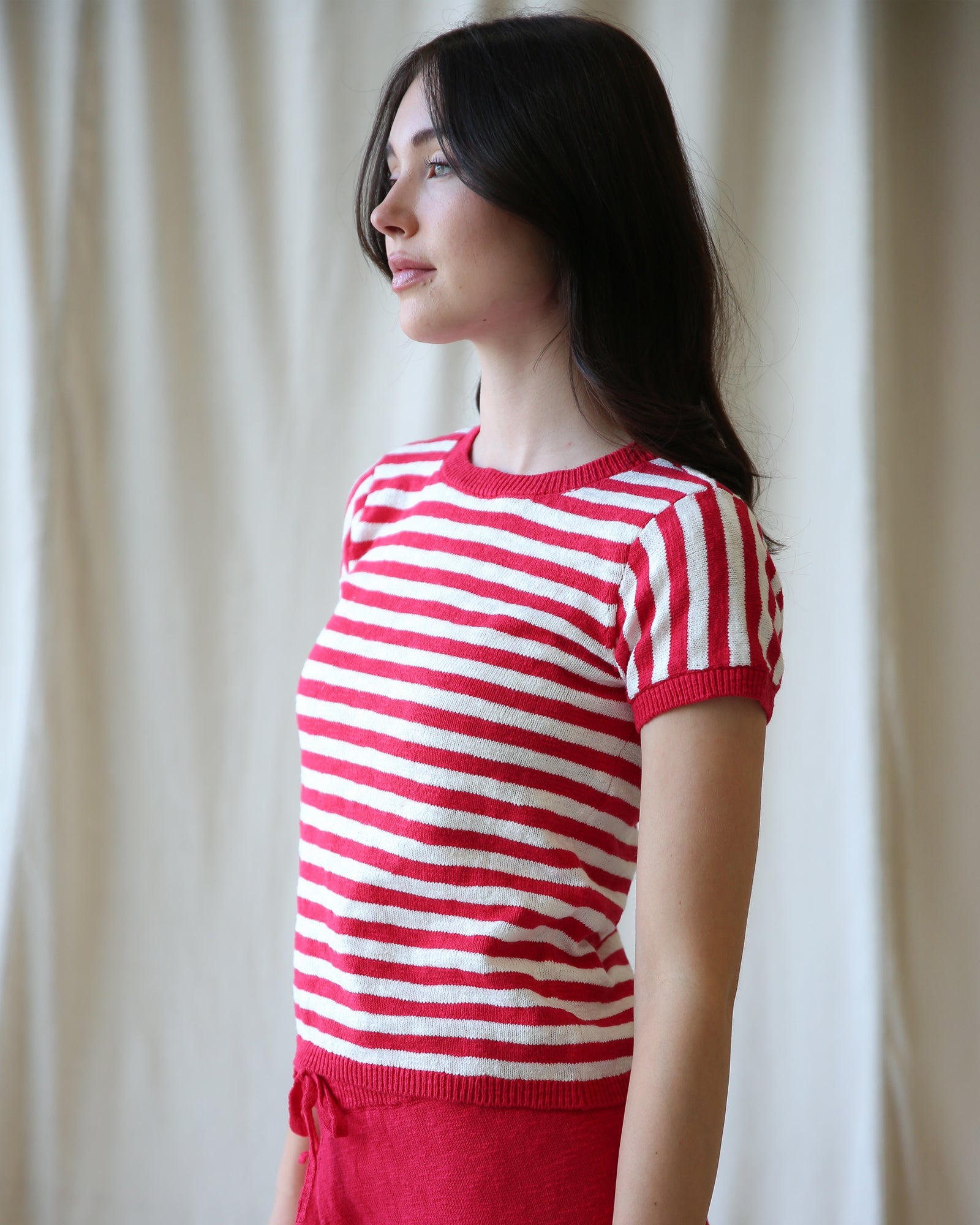 Woman wearing a red and white striped sweater against a plain background