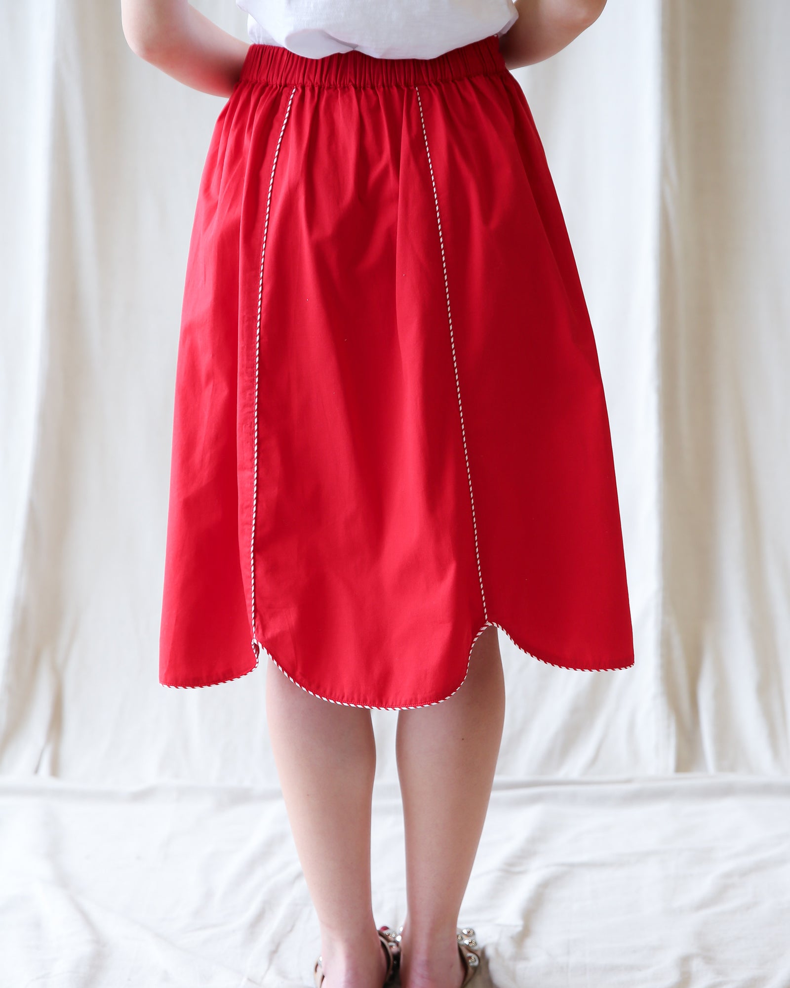 Red skirt worn by a person on a white background