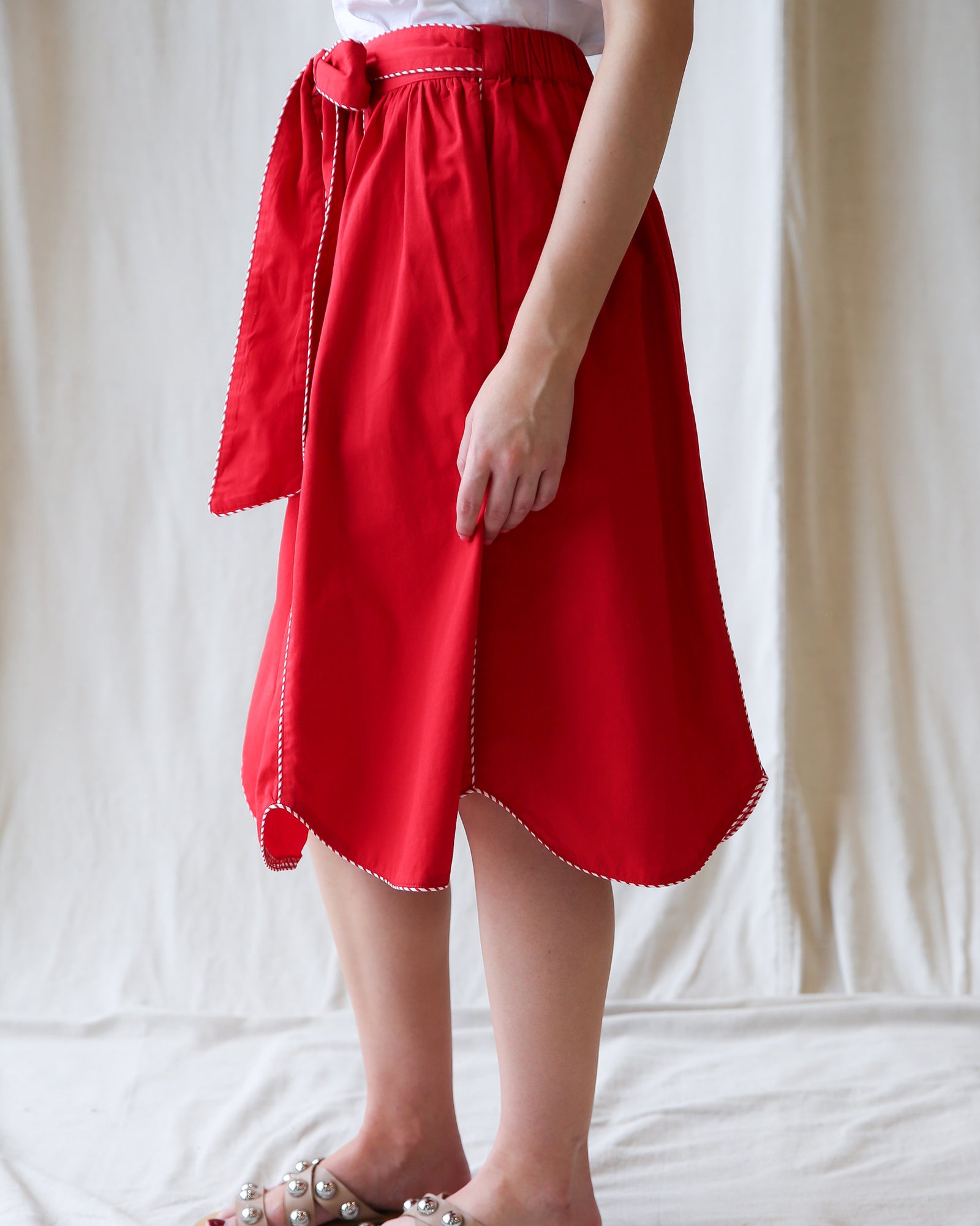 Red skirt with white trim worn by a person on a plain background