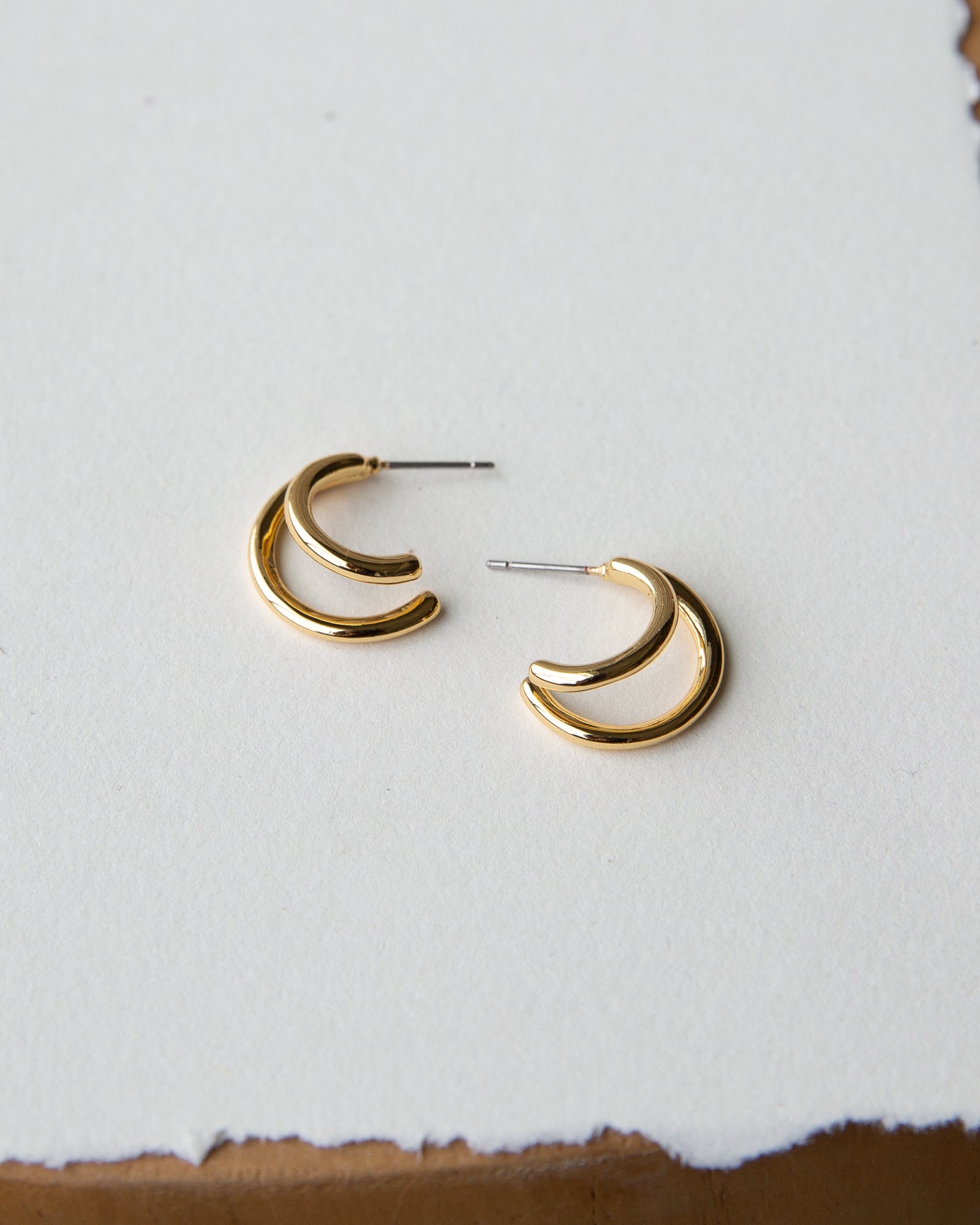 Gold hoop earrings on a light gray background