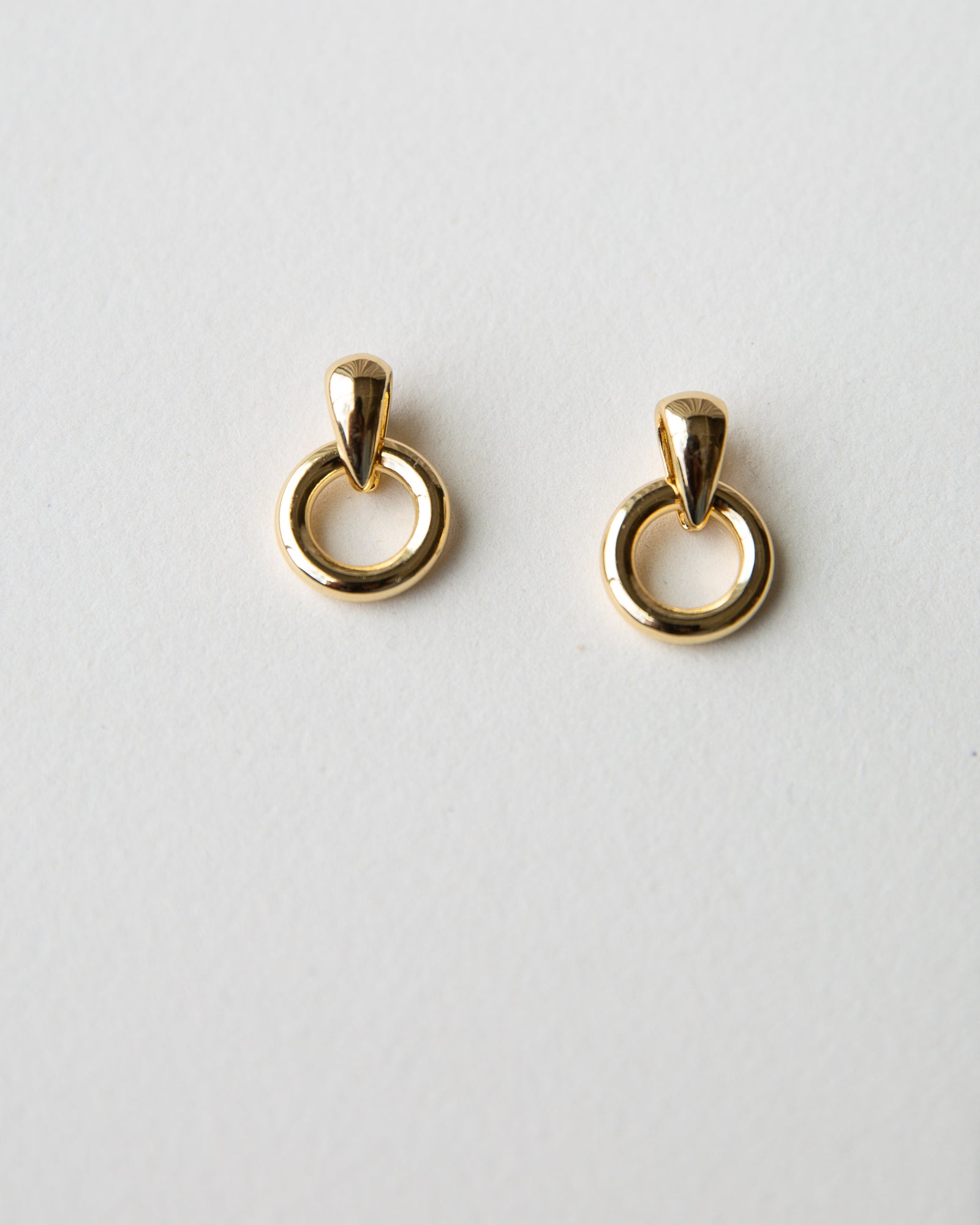 Gold hoop earrings on a light gray background