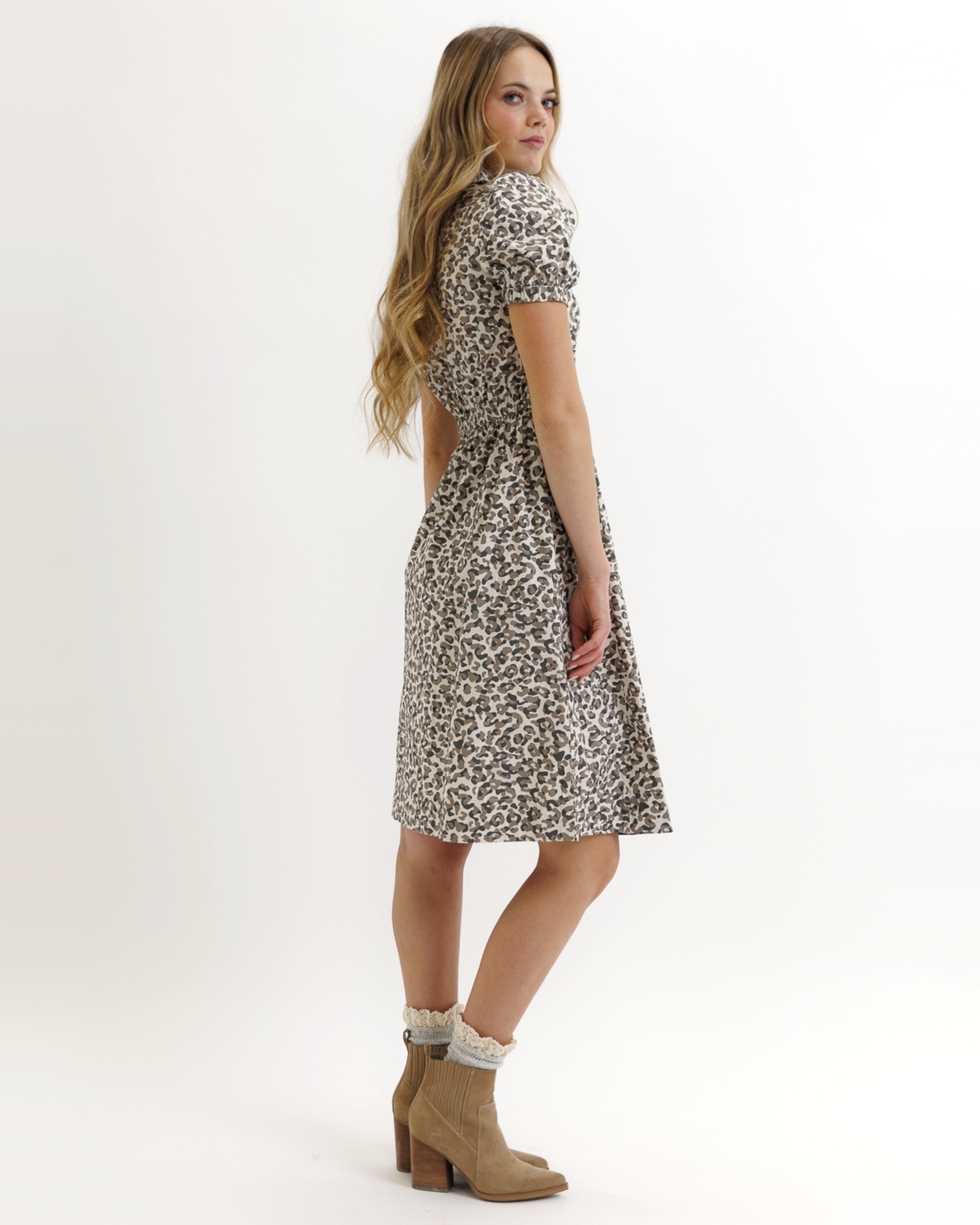 Woman wearing an animal print dress on a white background