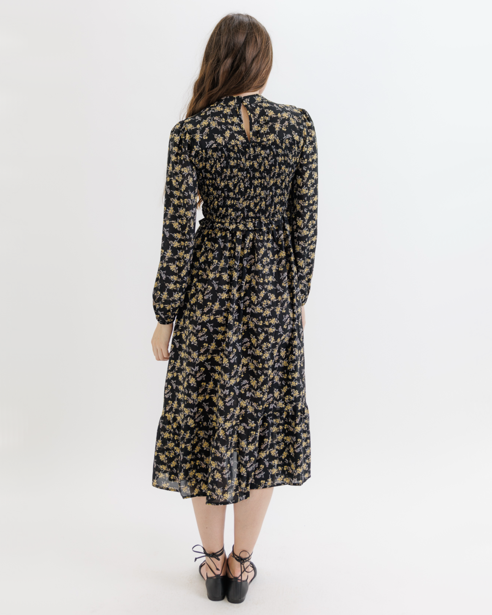 Woman wearing a black floral dress on a white background