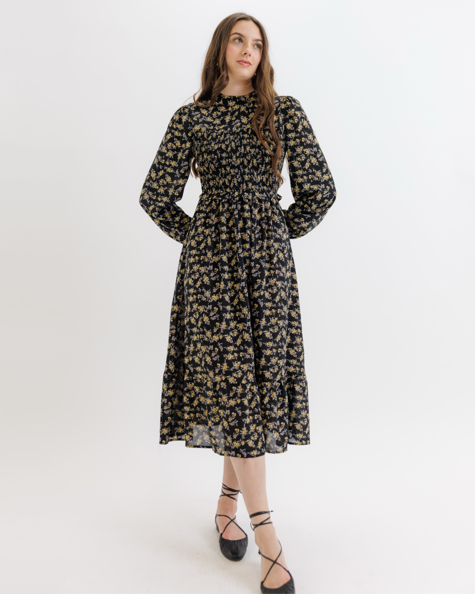 Woman wearing a black floral dress on a white background