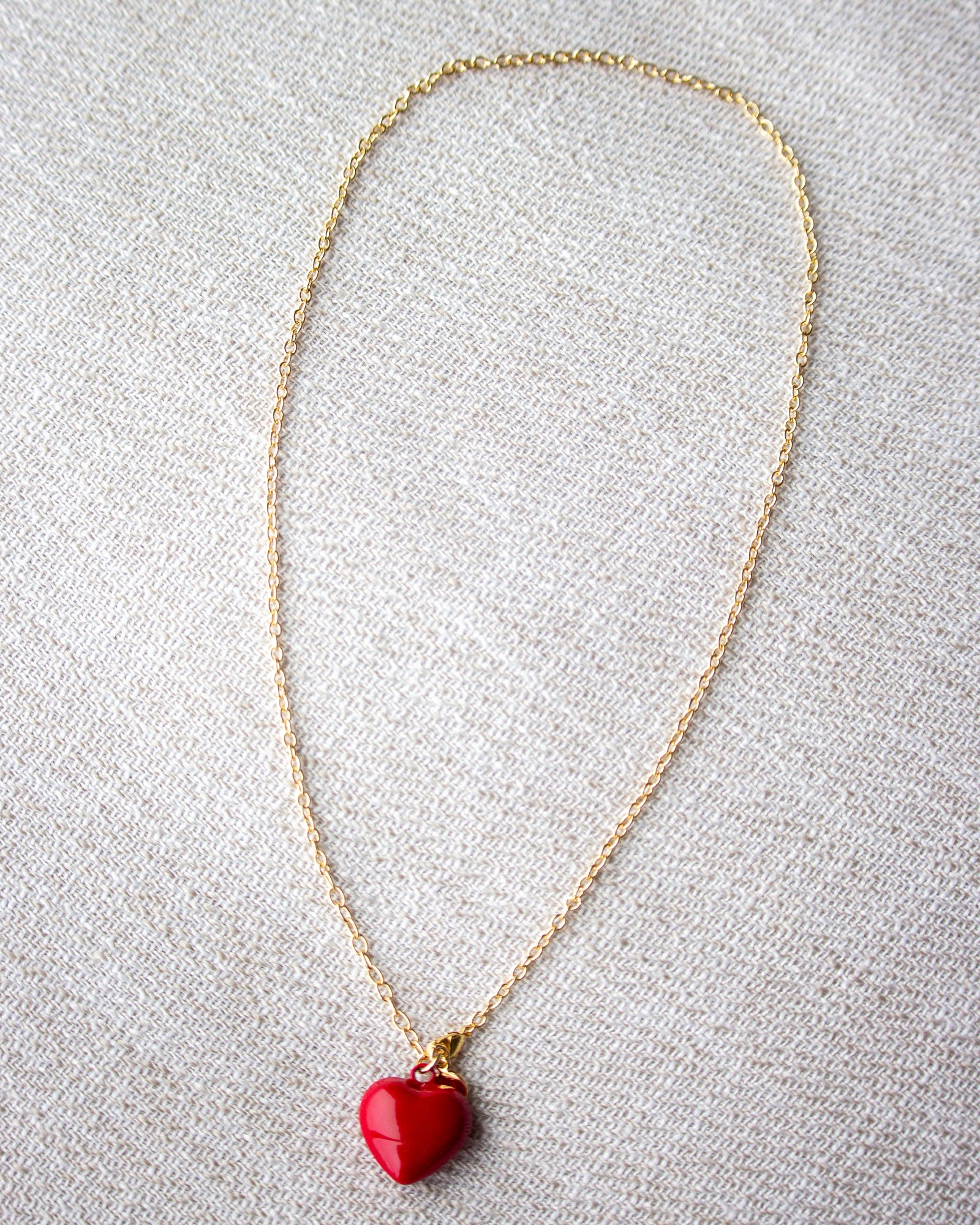 Necklace with a red heart pendant on a light gray background