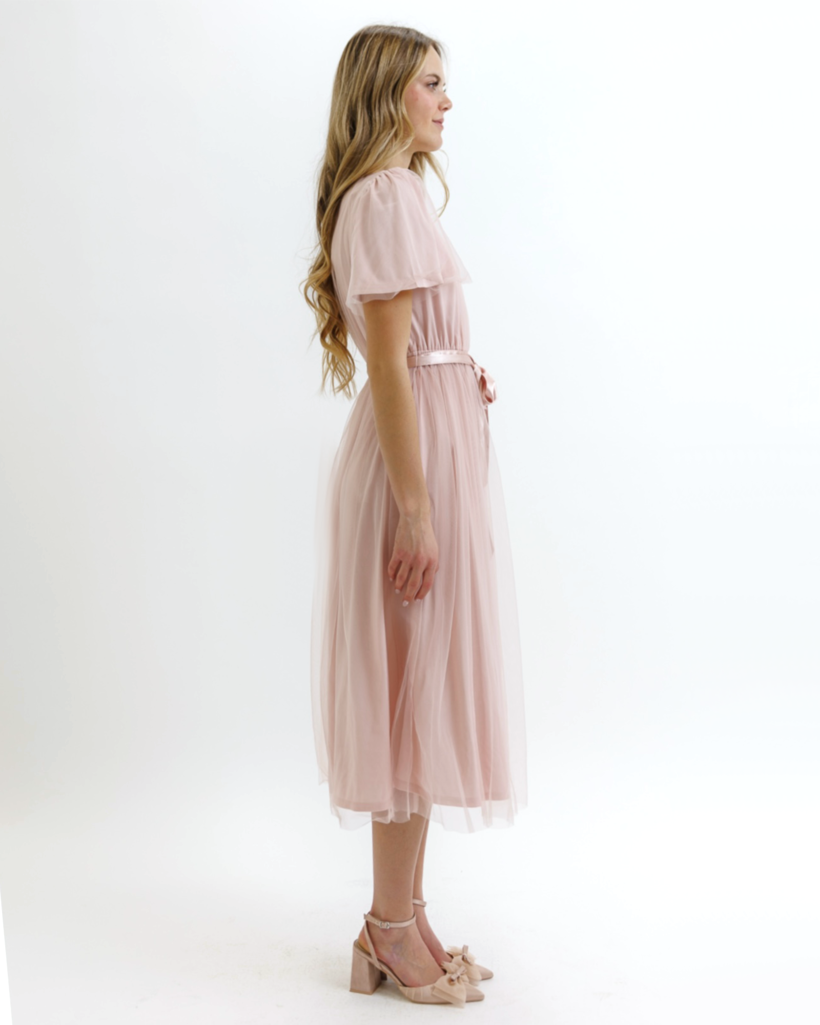 Woman wearing a light pink dress on a white background