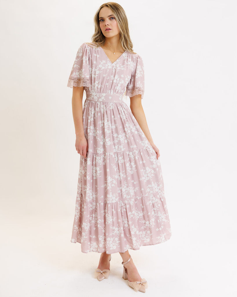 Model wearing a pink floral print short flutter sleeve, v-neck, maxi dress with tiered skirt.