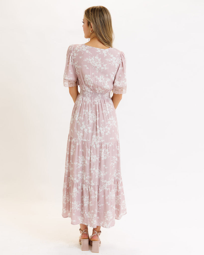 Model wearing a pink floral print short flutter sleeve, v-neck, maxi dress with tiered skirt.